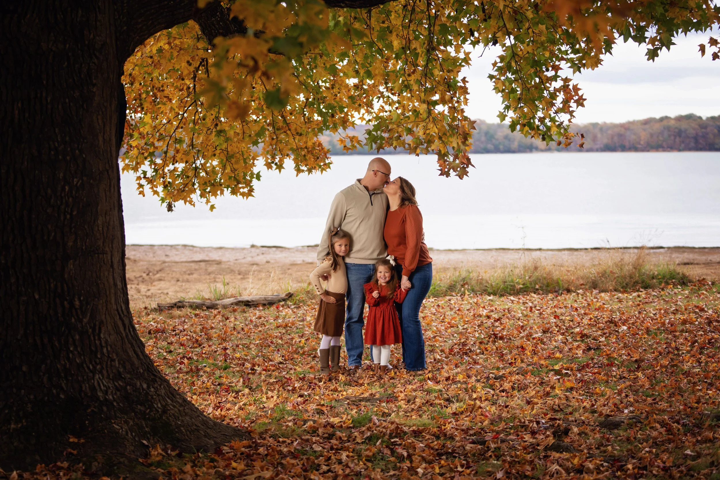 Family of four beneath an autumn tree by the lake, photographed by Matt and Shea Photography in Chattanooga, Tennessee