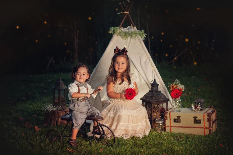 Siblings photographed beside a glowing Twilight tent