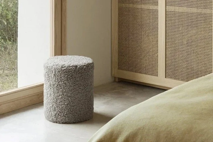 This  Pouf is upholstered in fluffy, poodly soft, curly fabric. This fun piece impresses with its cozy fabric and offers a wide range of uses. Thanks to the subtle, integrated handle, you can easily rearrange the pouf and use it as an ottoman or tabl