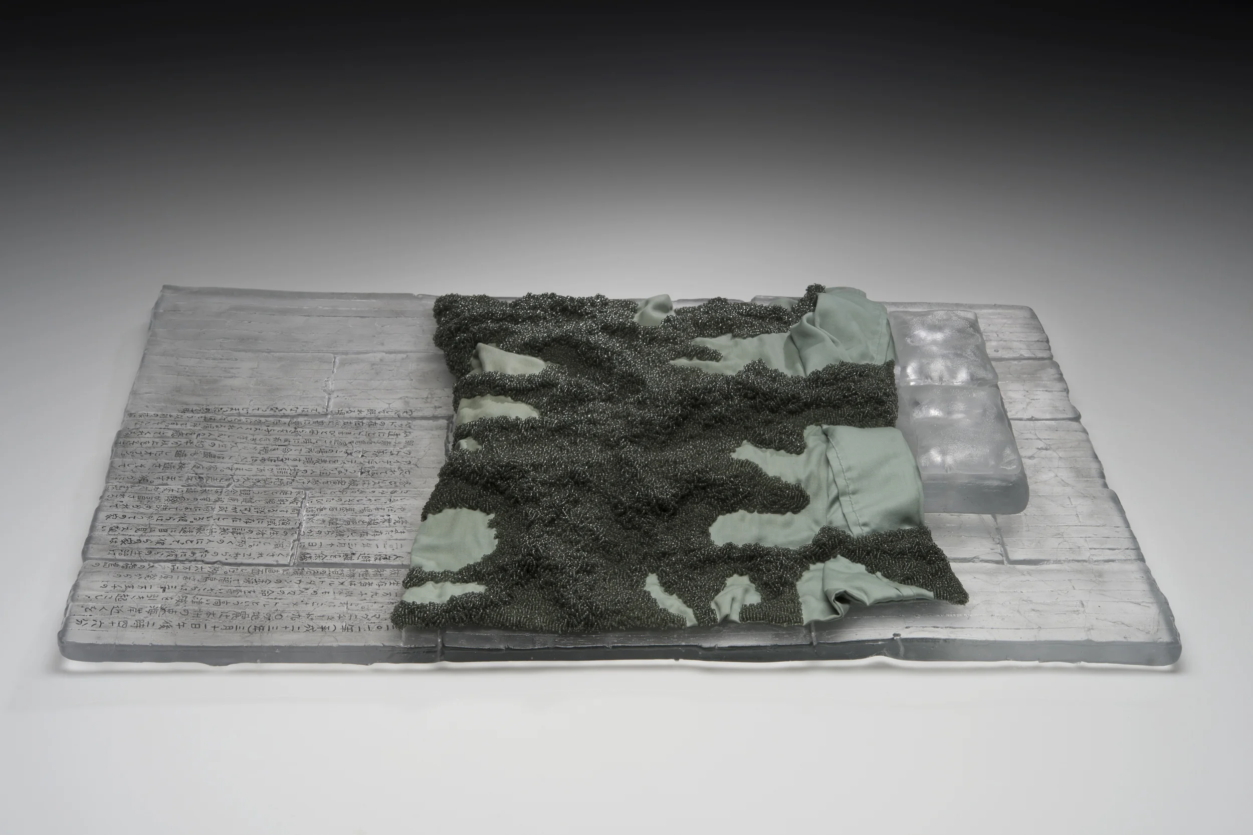 “Sixty-Two Thousand” 2013, cast glass, fabric, oil paint, thread, 62,000 seed beads from Japan, 27" x 18" x 6” Photographer: Elizabeth Torgerson-Lamark