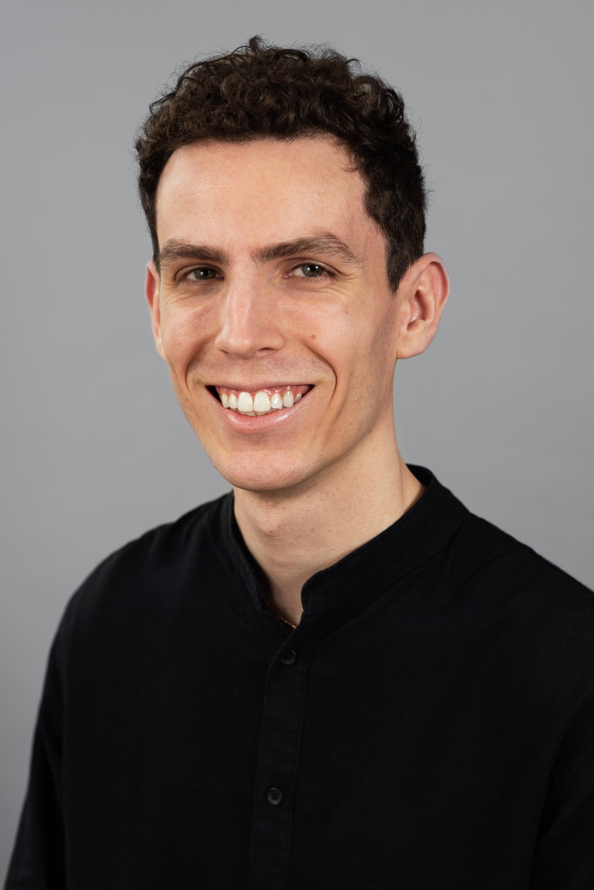  Corporate headshot of man in a black buttondown by Ari Scott, NYC headshot photographer. 