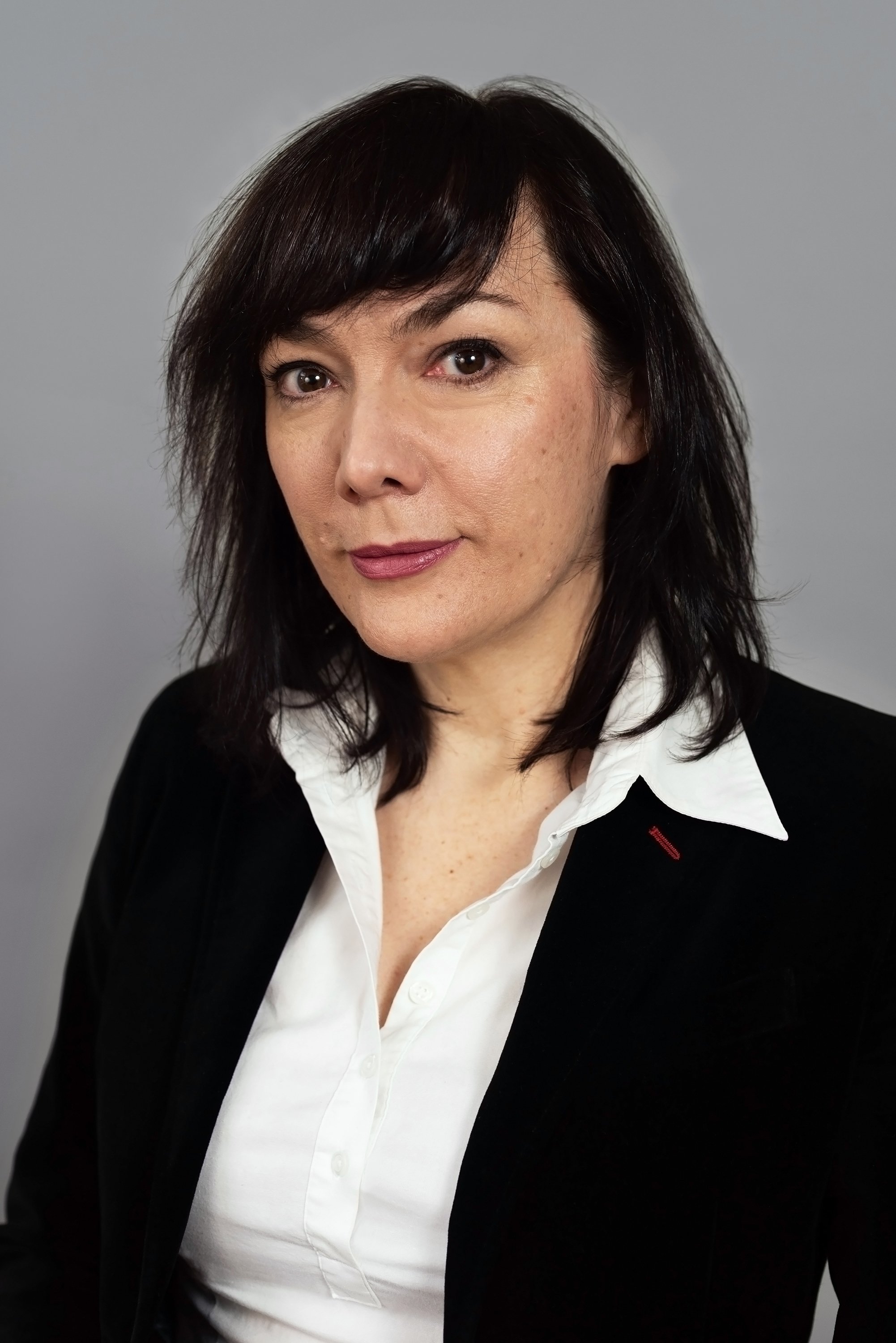 Corporate headshot of woman in a dark jacket and white top by Ari Scott, NYC headshot photographer. 