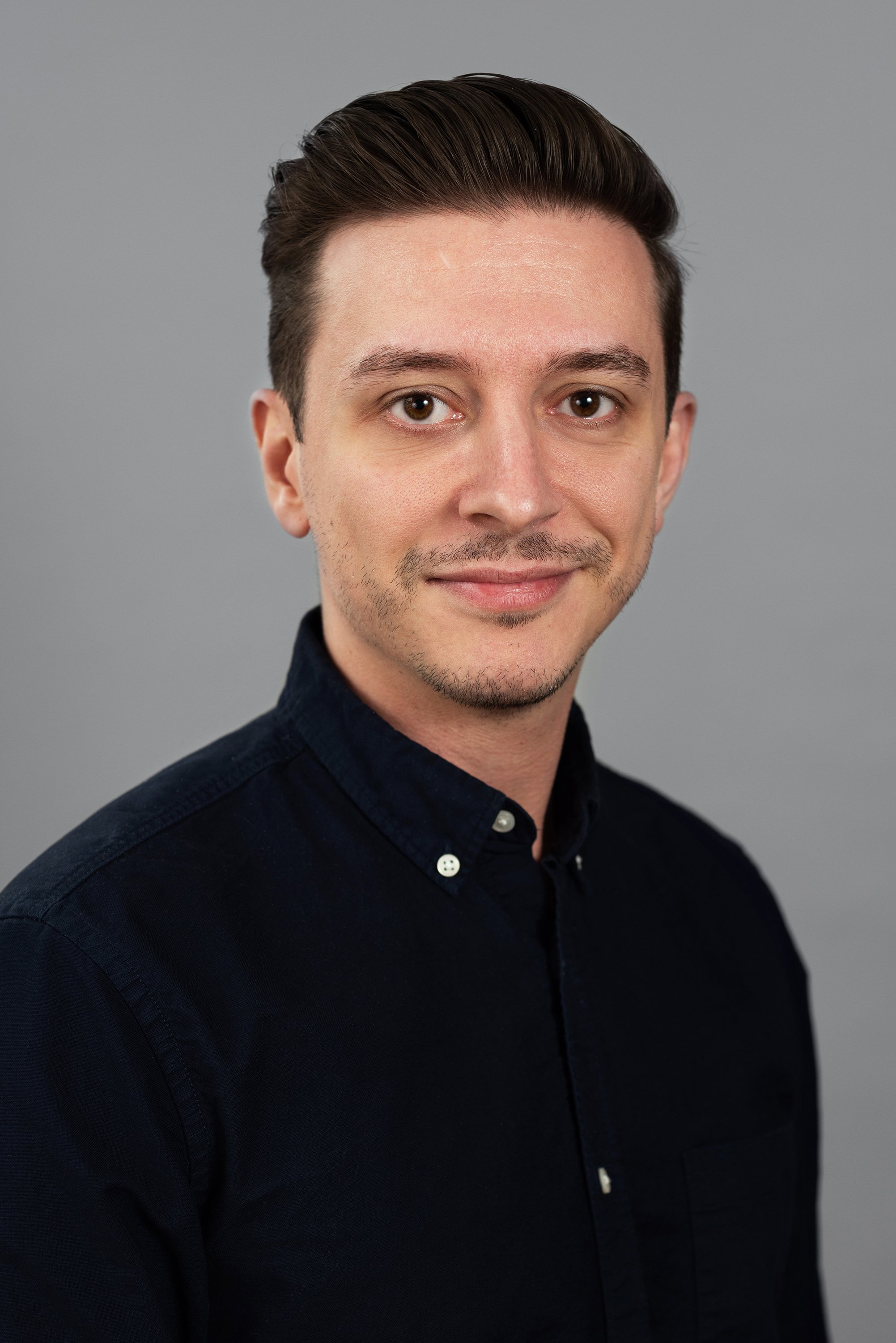  Corporate headshot of man in a dark buttondown shirt by Ari Scott, NYC headshot photographer. 