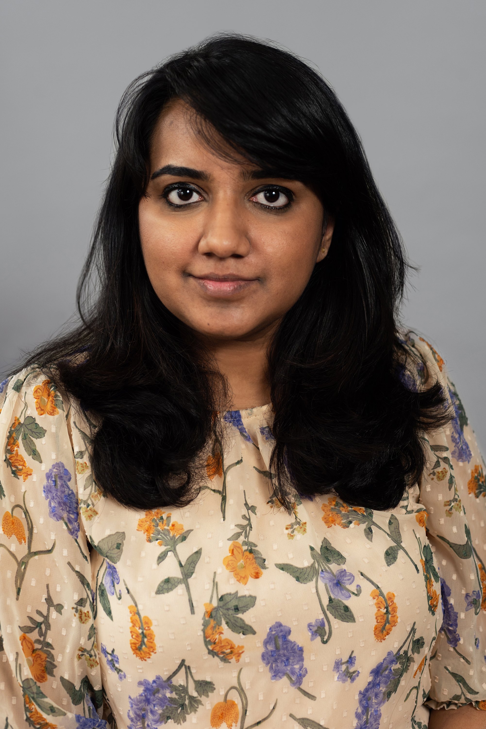  Corporate headshot of woman in a beige blouse with colored flowers by Ari Scott, NYC headshot photographer. 