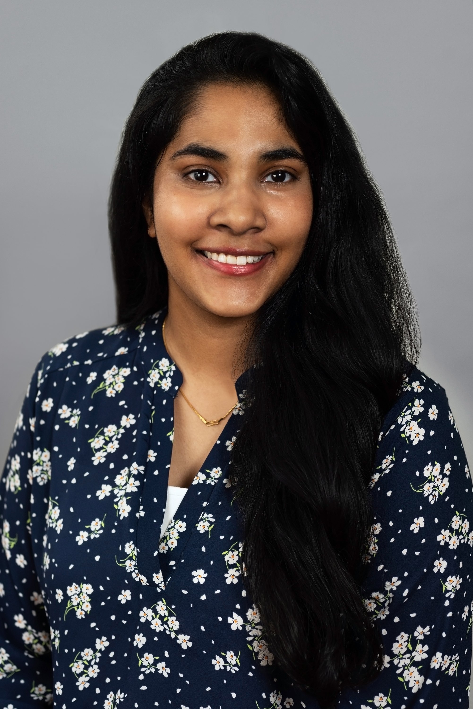  Corporate headshot of a woman in a dark blue flowered blouse by Ari Scott, NYC headshot photographer. 