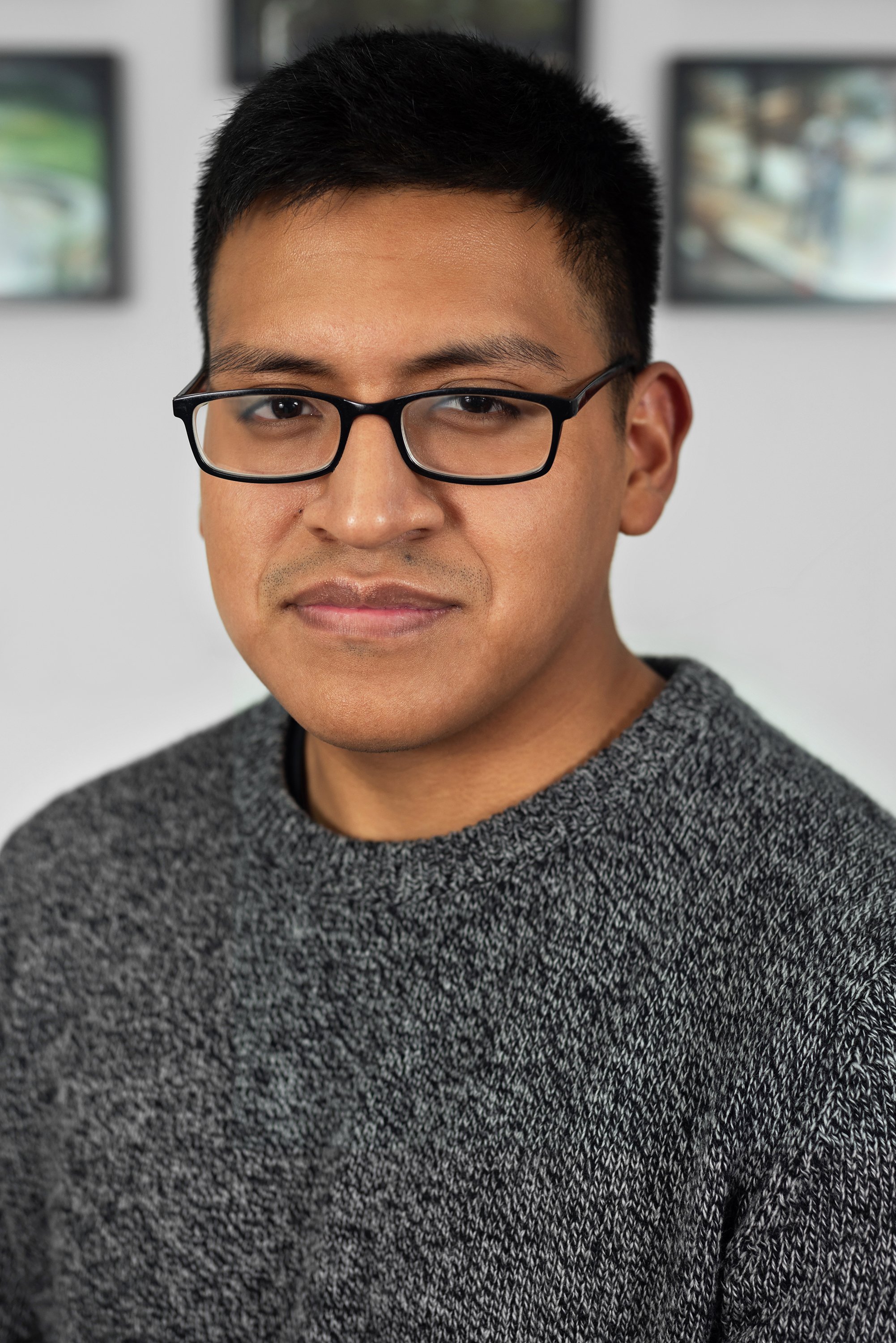  Corporate headshot of man in a gray sweater and glasses by Ari Scott, NYC headshot photographer. 