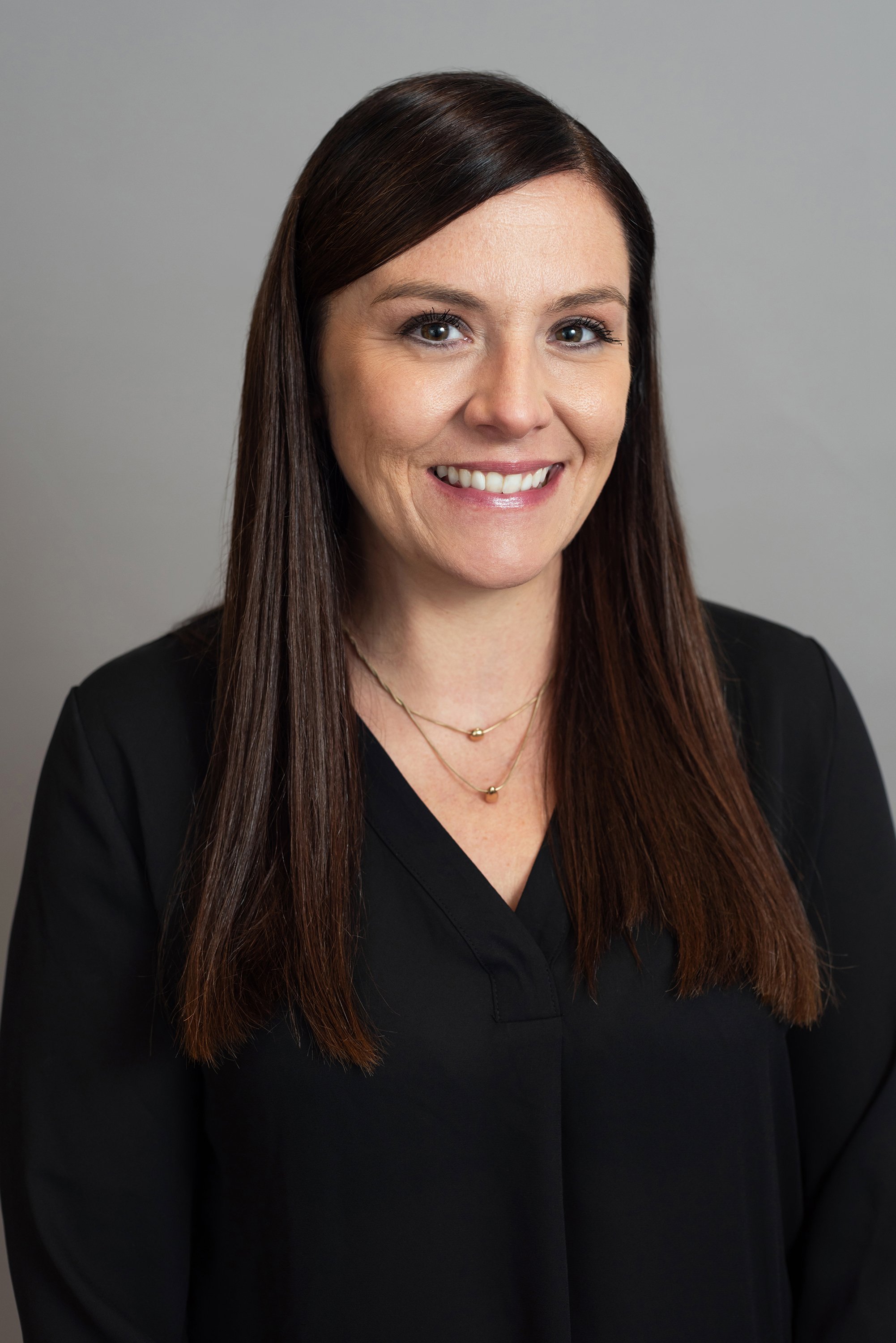  Corporate headshot of woman in v-neck black shirt by Ari Scott, NYC headshot photographer. 