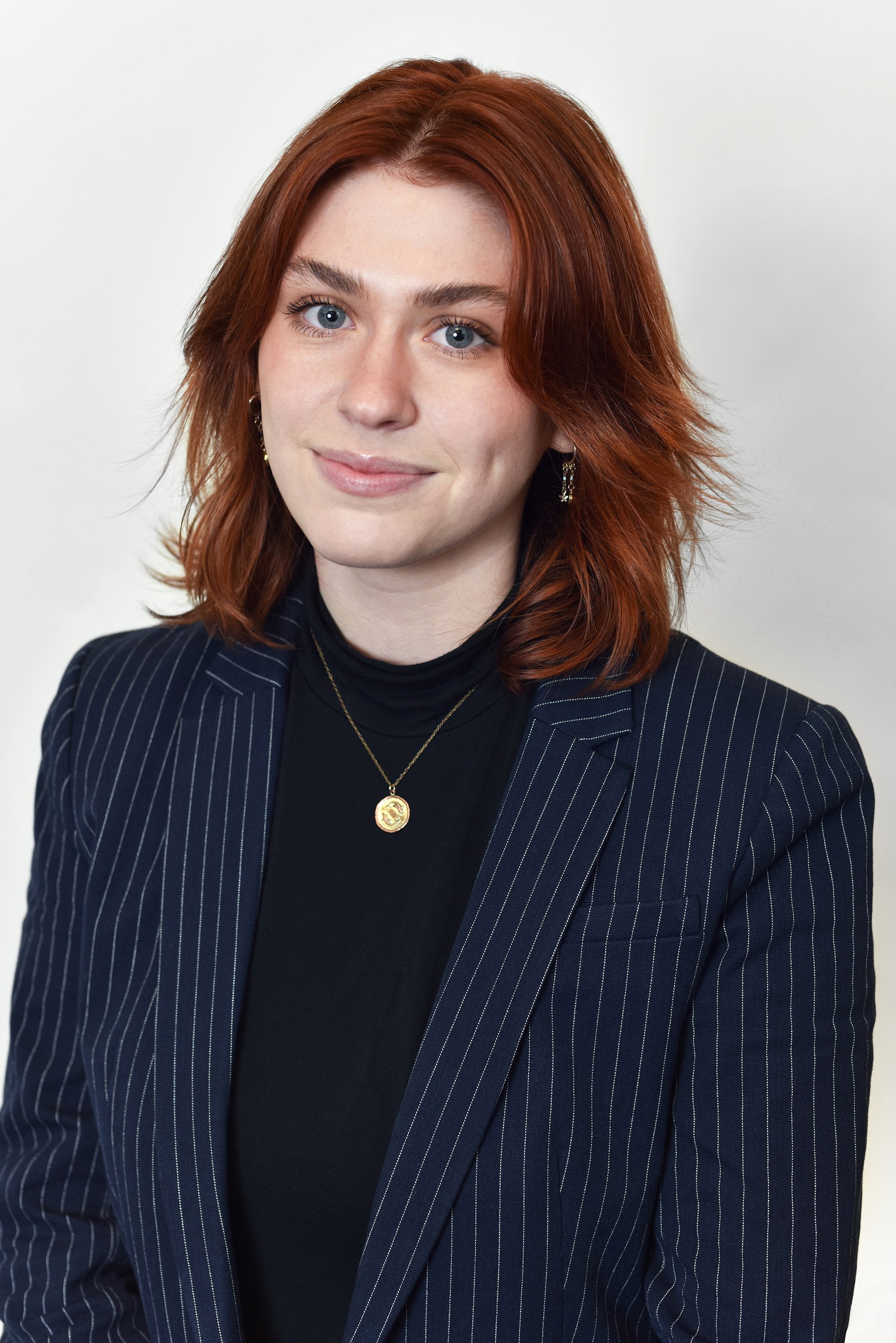  Corporate headshot of a woman wearing a pin striped blazer and black shirt by Ari Scott, NYC headshot photographer. 