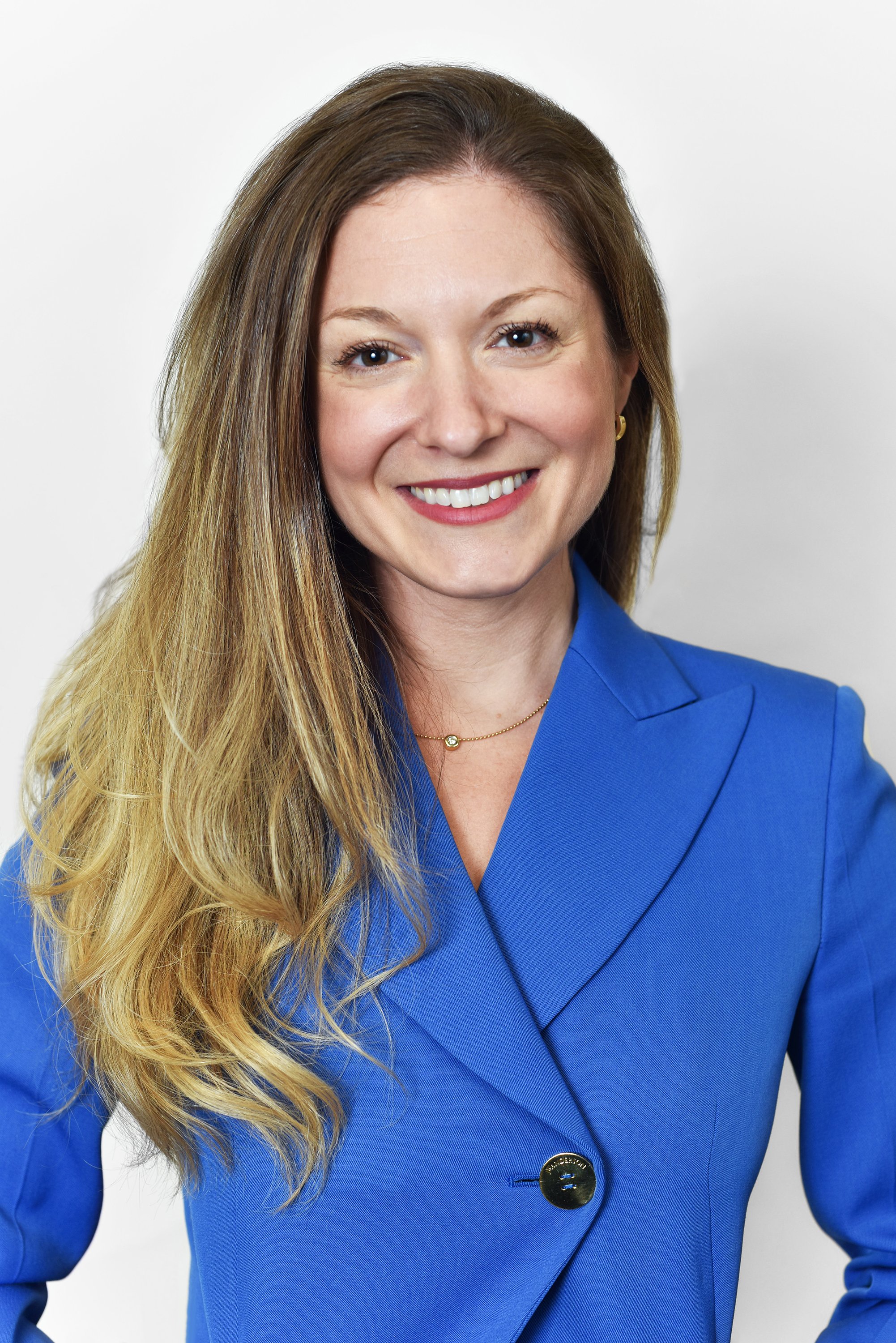  Corporate headshot of woman in a bright blue blazer by Ari Scott, NYC headshot photographer. 