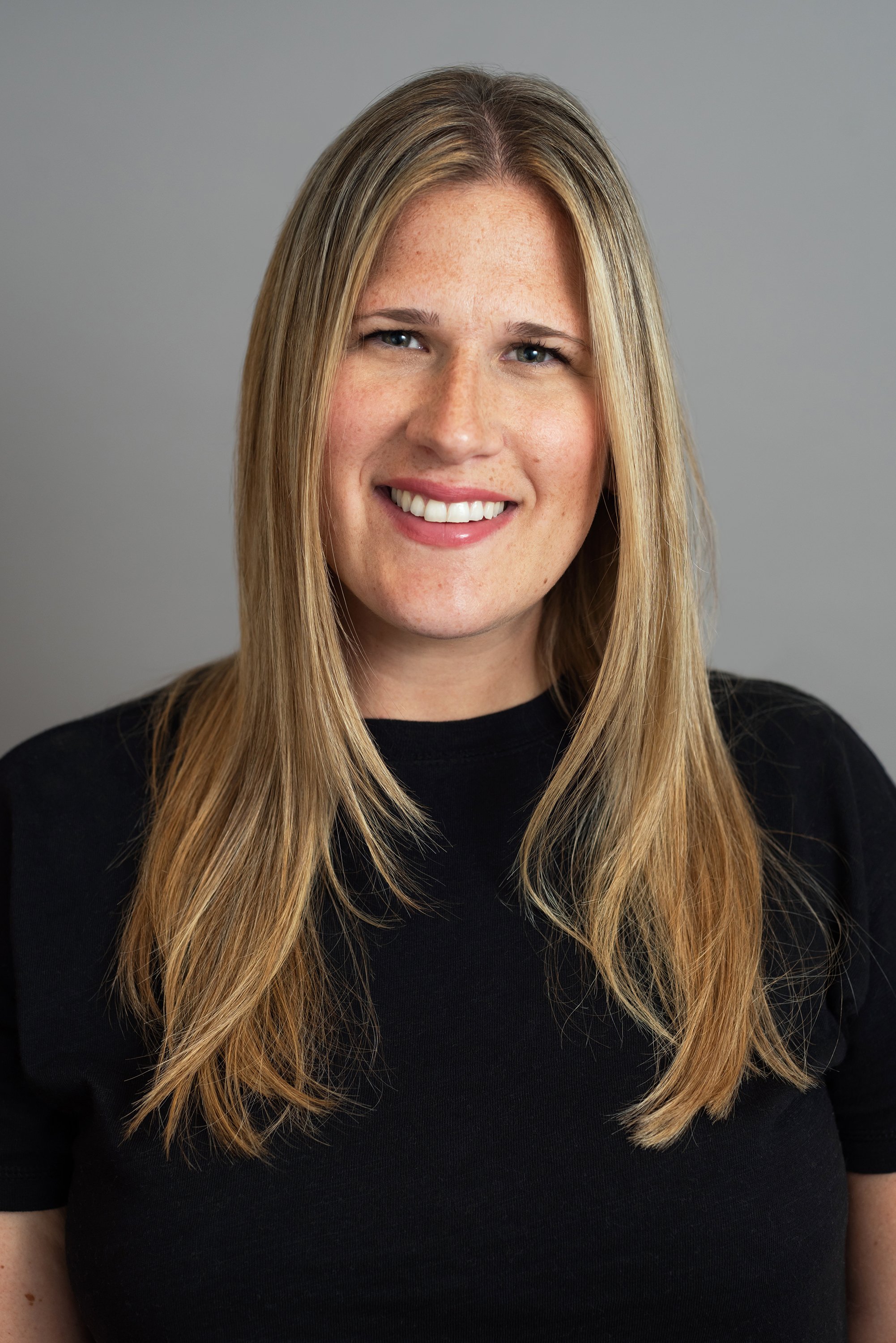  Corporate headshot of a woman wearing a dark t-shirt by Ari Scott, NYC headshot photographer. 