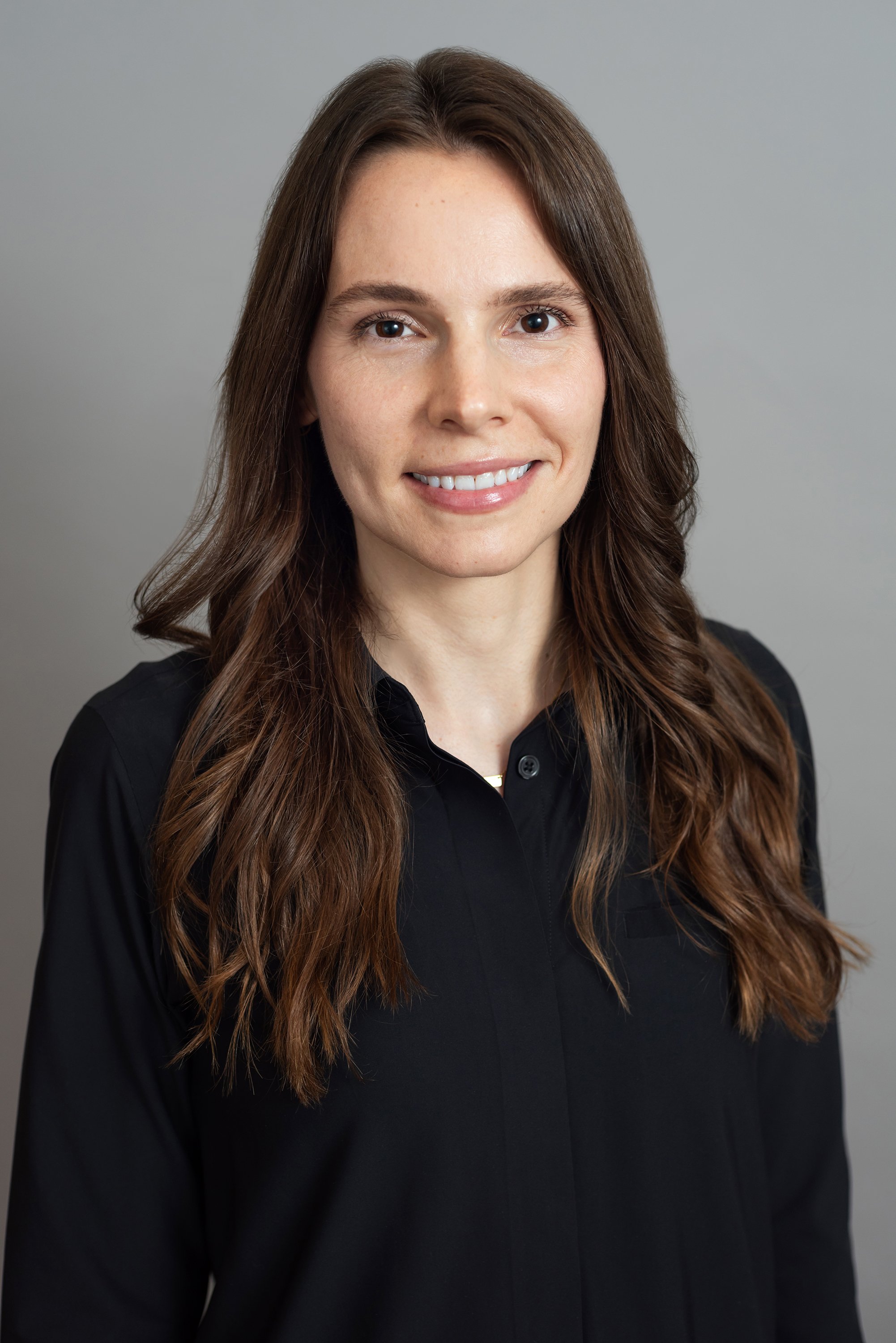  Corporate headshot of a woman in a black buttondown top by Ari Scott, NYC headshot photographer. 