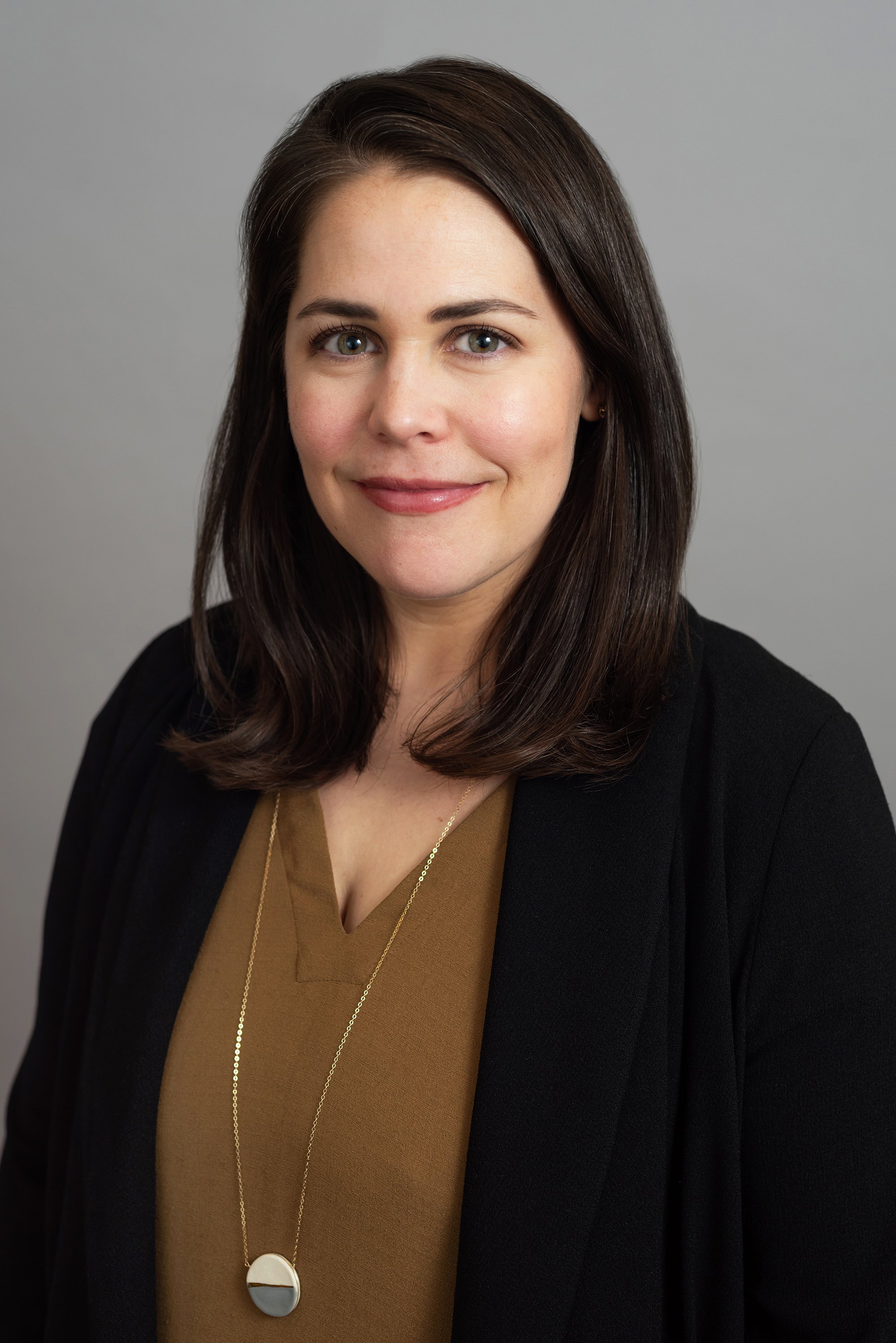  Corporate headshot of a woman in a black blazer and a brown shirt by Ari Scott, NYC headshot photographer. 