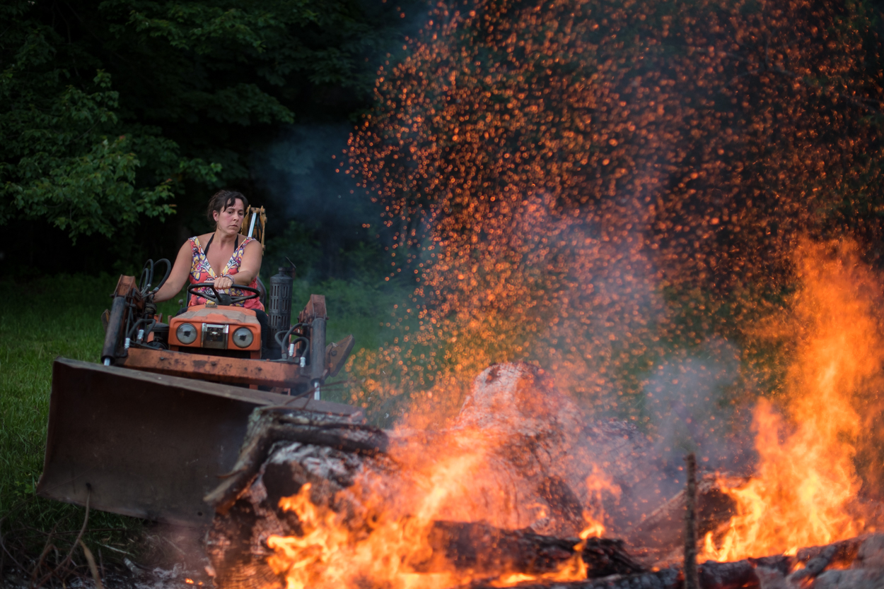 Mary Rafter tends to a bonfire in preparation for a backyard lobster bake in Bremen Sunday, July 3, 2016.