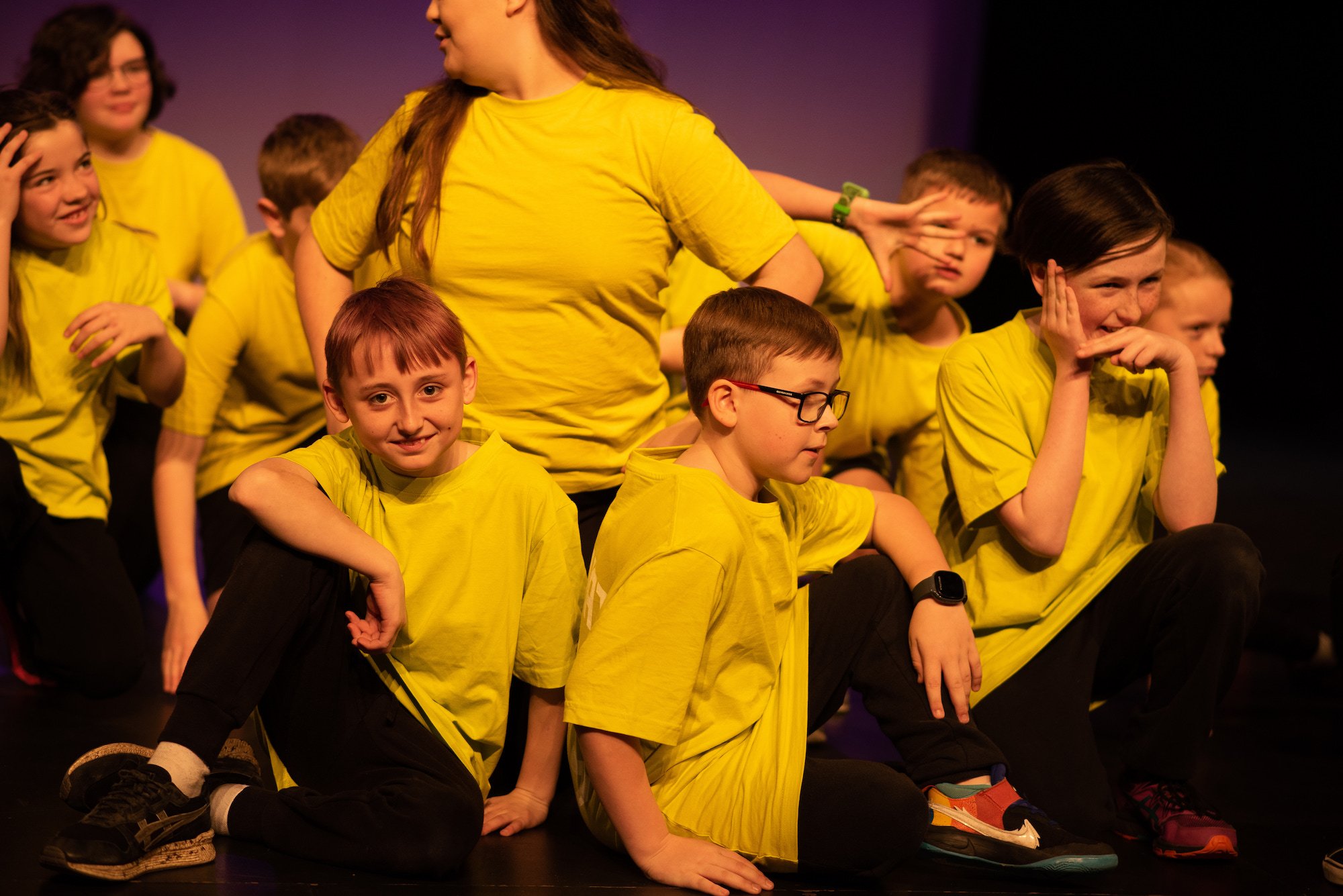  students in yellow crouching together in clump 