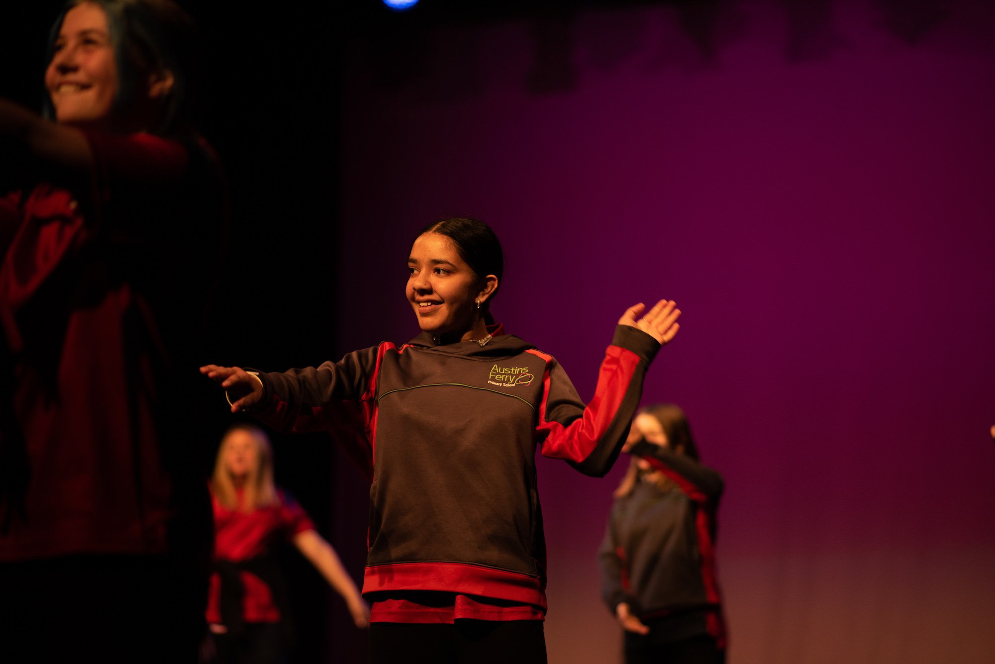  student smiling while dancing on stage 