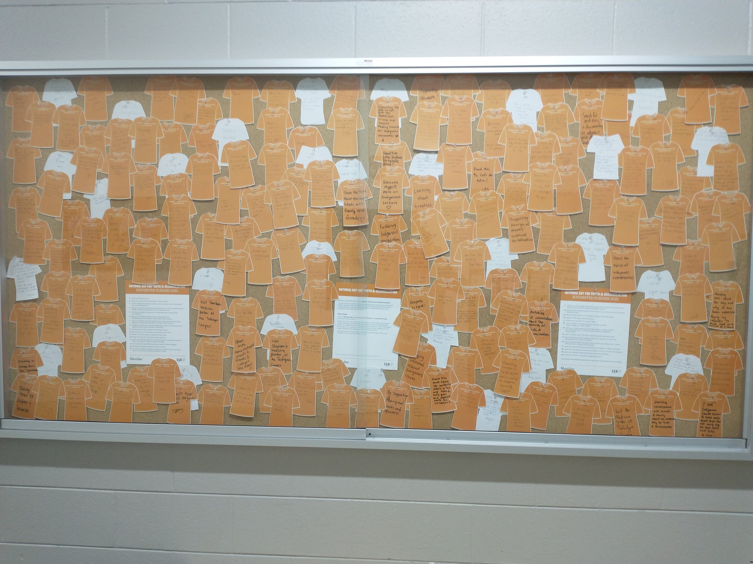  A board with paper orange shirts posted on the wall with encouraging and hopeful message. 