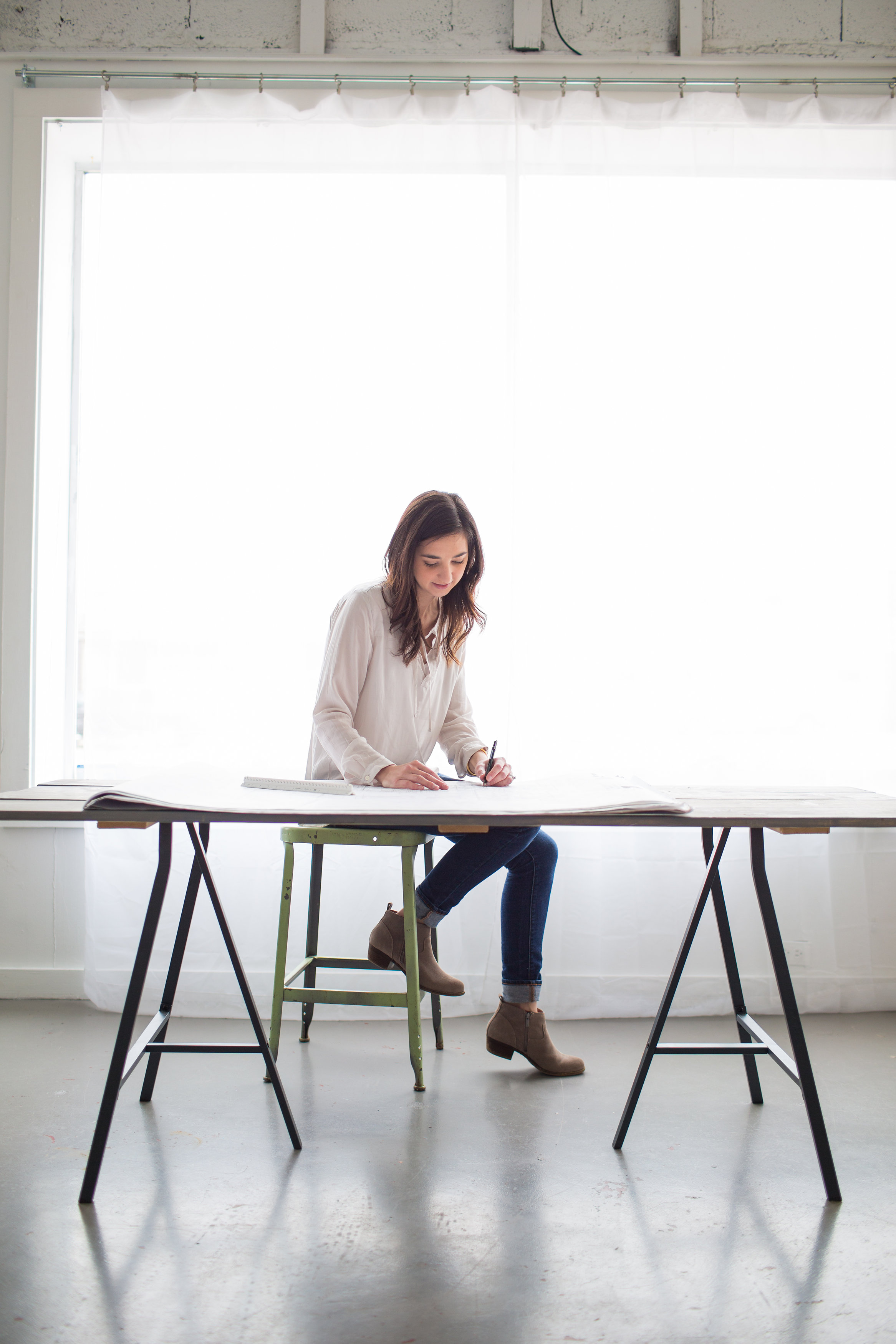 Jenn DeBord is sitting at a table working on plan drawings for a kitchen remodel in Knoxville Tennessee.