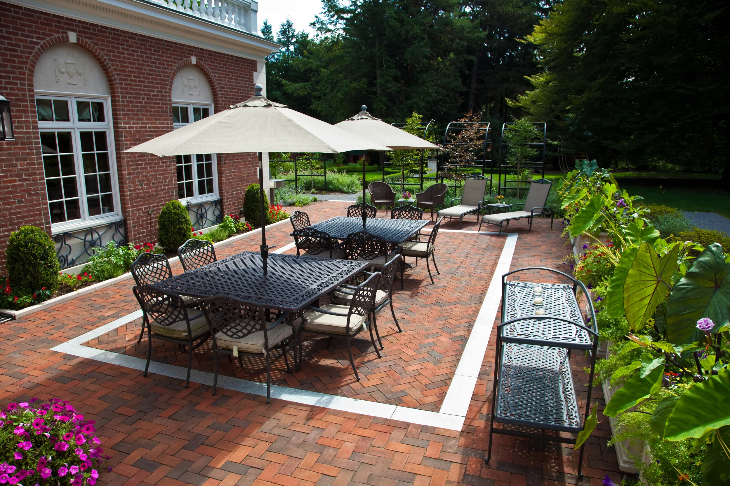 The clay bricks are laid in an herringbone bond with a custom granite inset. We created a new large terrace that leads from the new family room. The area has multiply views out into the various gardens. This area is for parties, dining and family. 