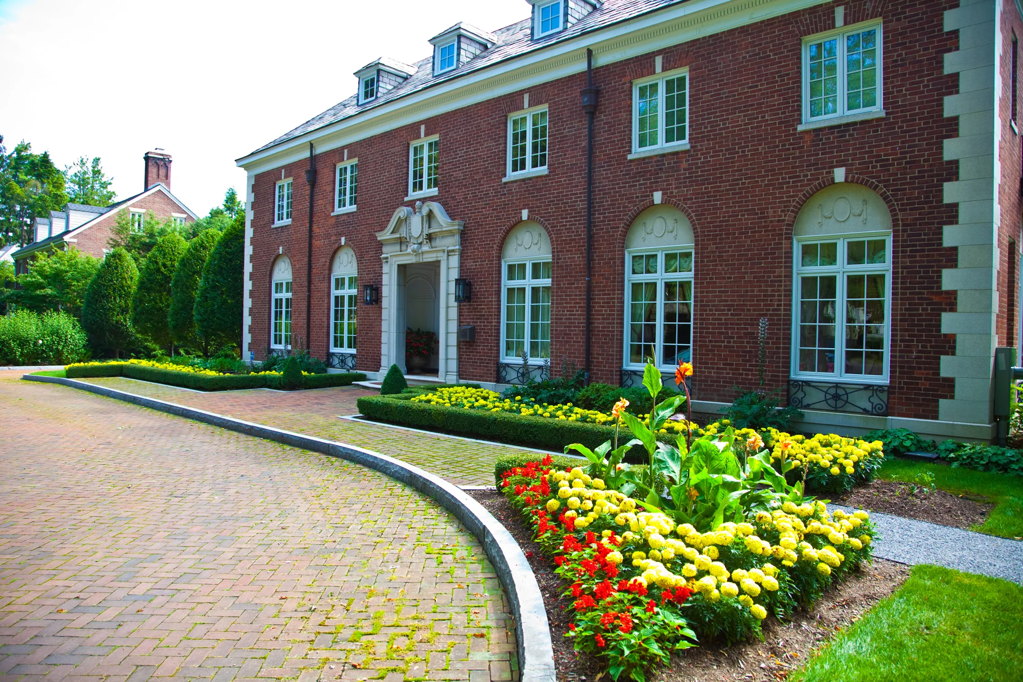 The front of the house is laid out with formal plantings, a mixture of annuals and perennials for a colorful entrance to this property.