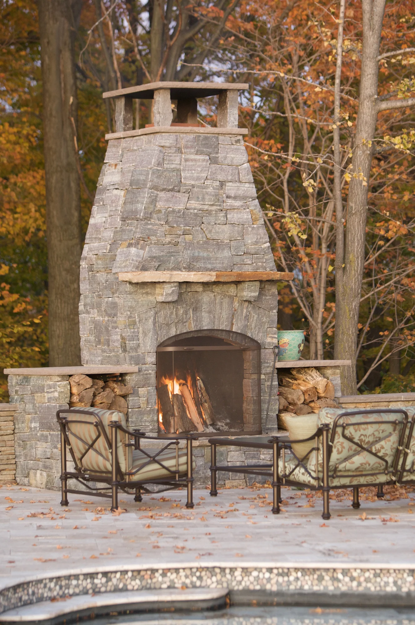 Natural stone fireplace with mantle and wood storage eitherside of the fireplace insert.
