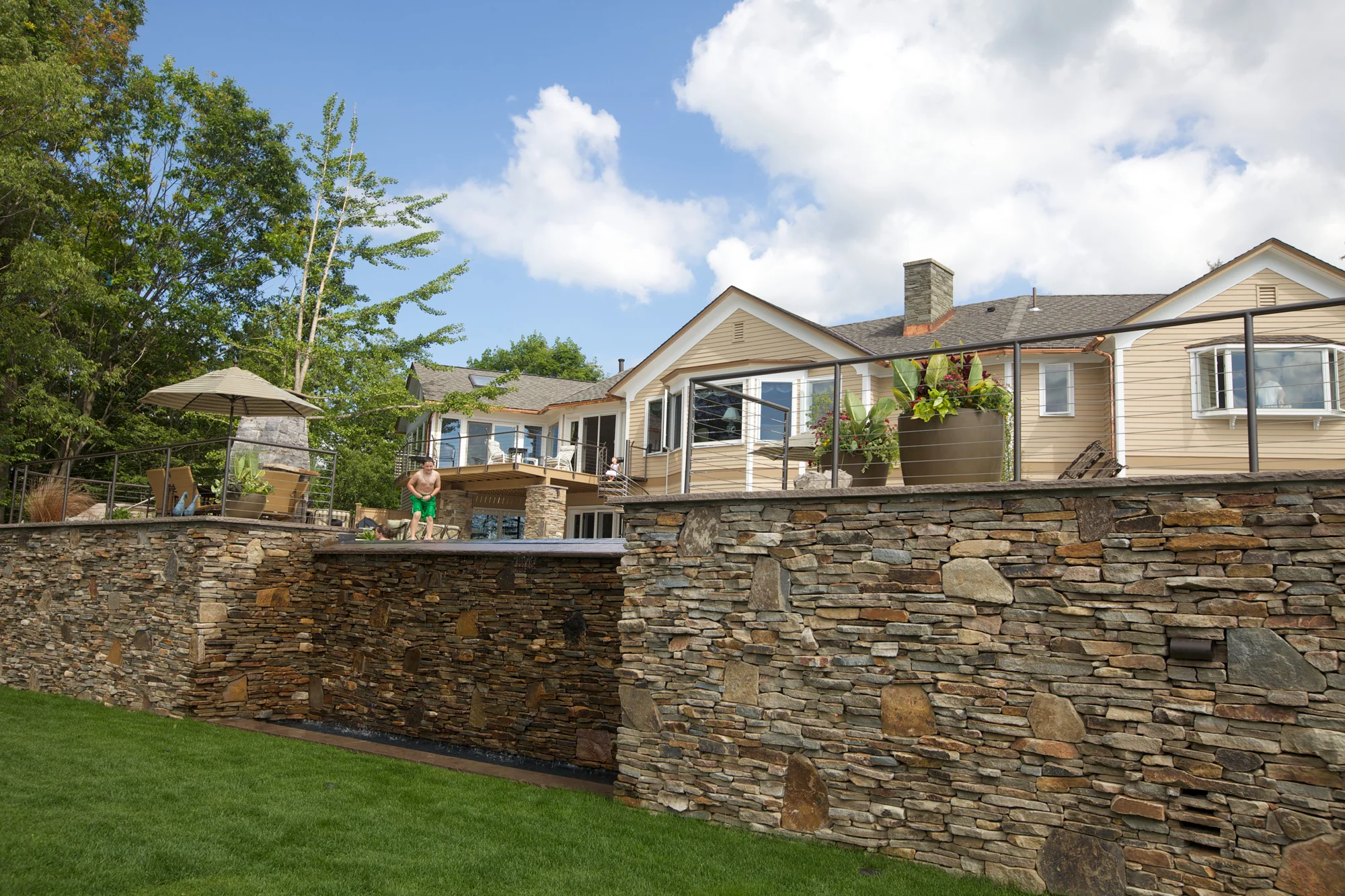 Waterfall stone wall for the vanishing edge of the pool. We added built in pool benches along this edge for seating in the 9ft deep pool.