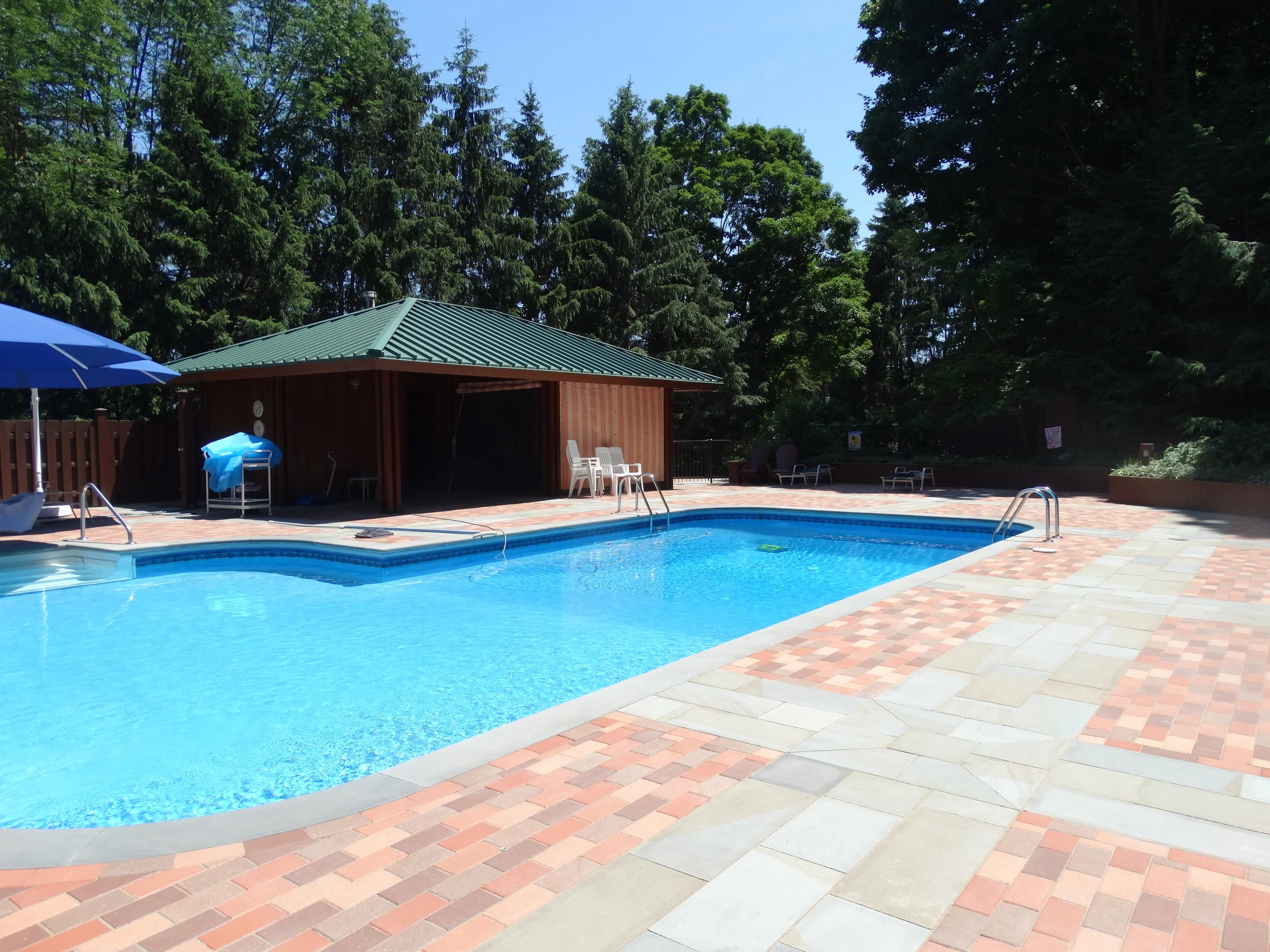  Completed project with new clay pavers, custom bluestone bullnose pool coping and bluestone paver bands. 