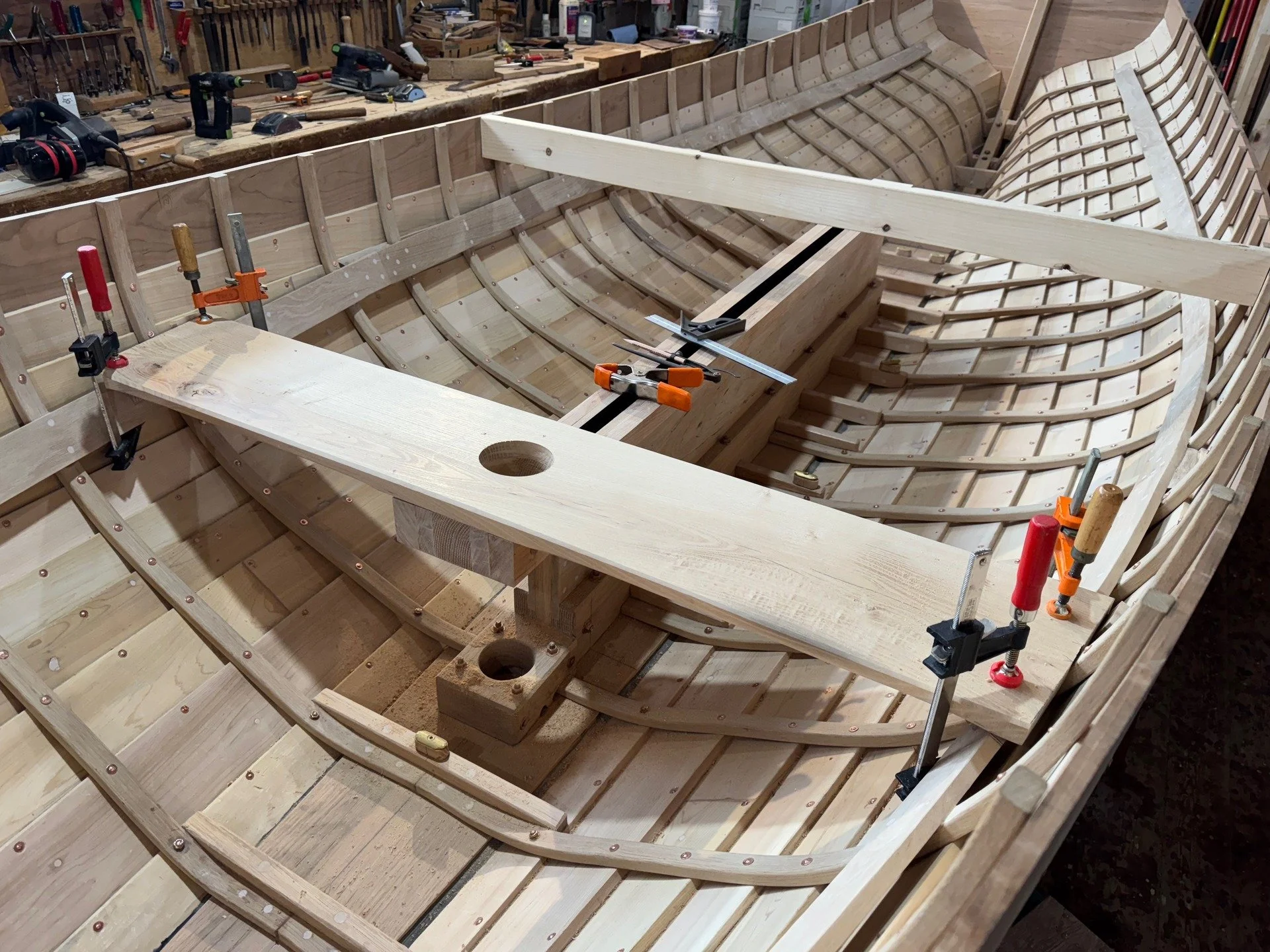 In this series I will fit and install the forward thwart and the cap for the centerboard case. Photo 1 shows the forward thwart ,with the hole for the mast, being fitted- lots to line up here. The second photo shows the cap being fitted to the case. 