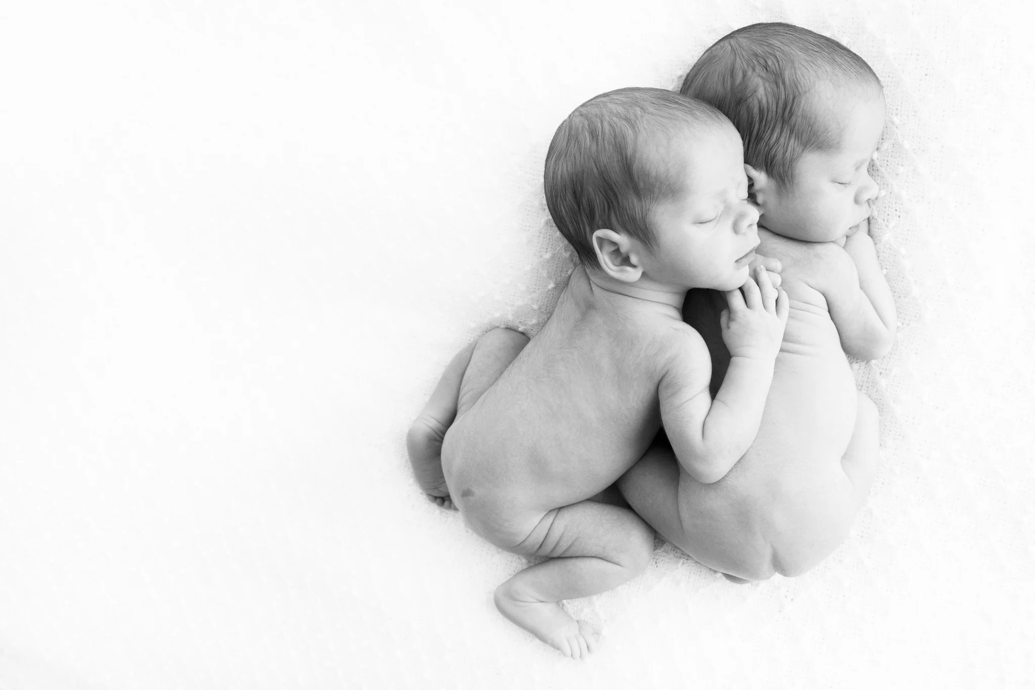 Newborn twin photography poses - twins cuddling each other.