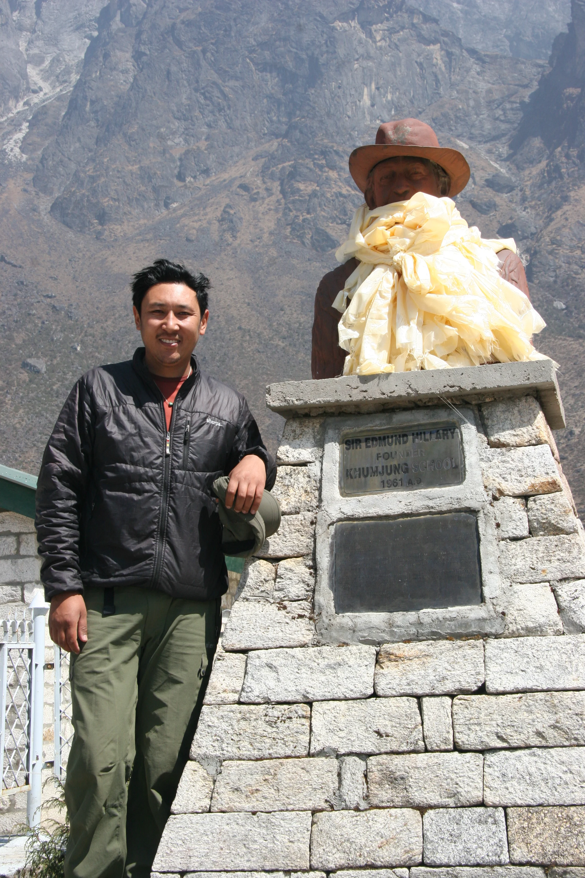 Mingma next to statue of sir edmund hillary