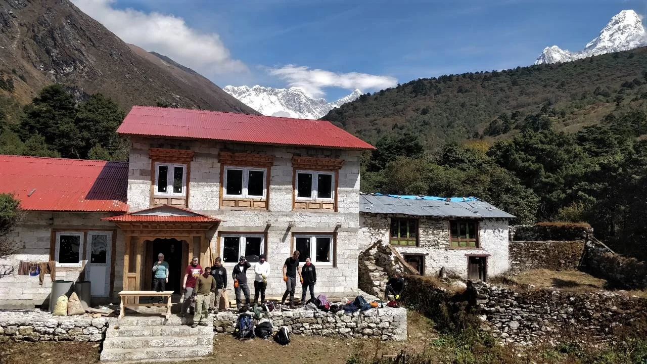 fall 2018 volunteers in front of building with Everest in background and ama dablam to the right.jpeg