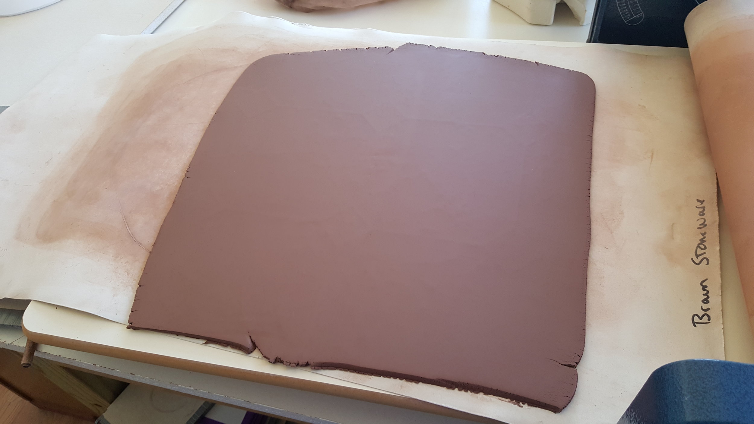 Red clay rolled out and ready to be formed.