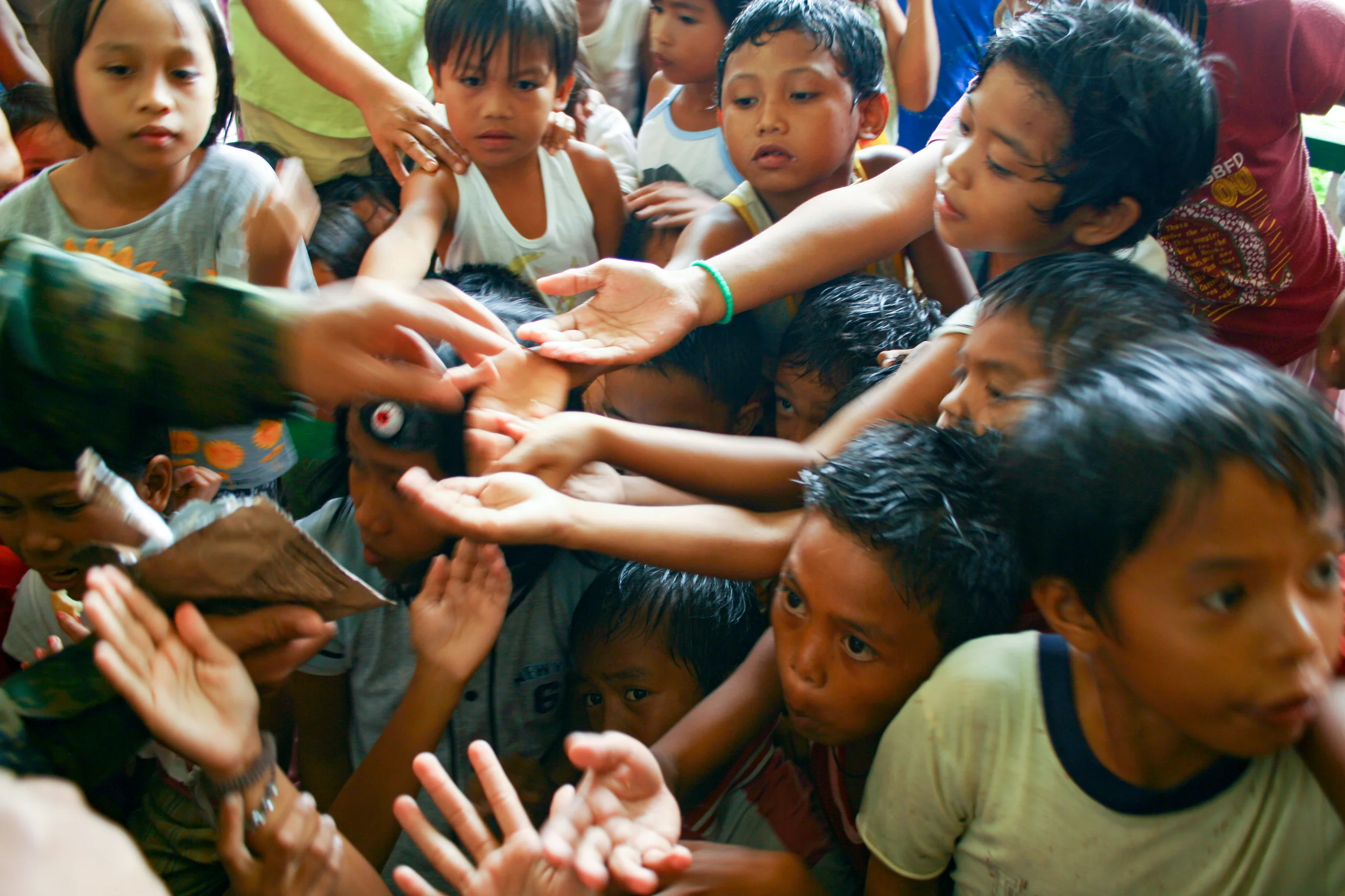 Children at the orphanage in Saint Bernard receive food from a U.S. Marine (Leyte, Philippines).