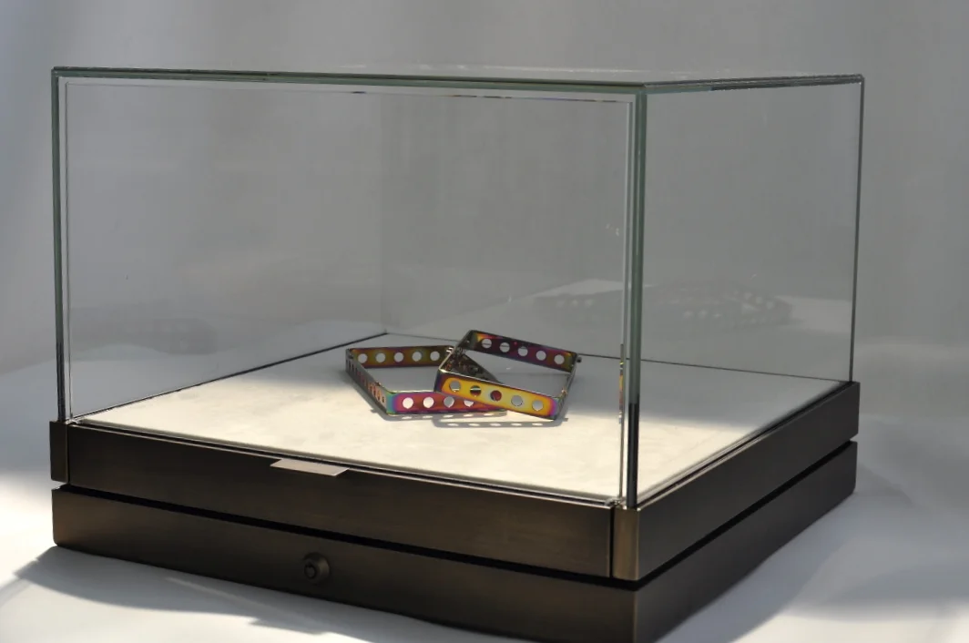   Vetrinetta per show room:&nbsp; Vetrina in metallo bronzato, campana in vetro extrachiaro, apertura con tiretto su guide lineari. 