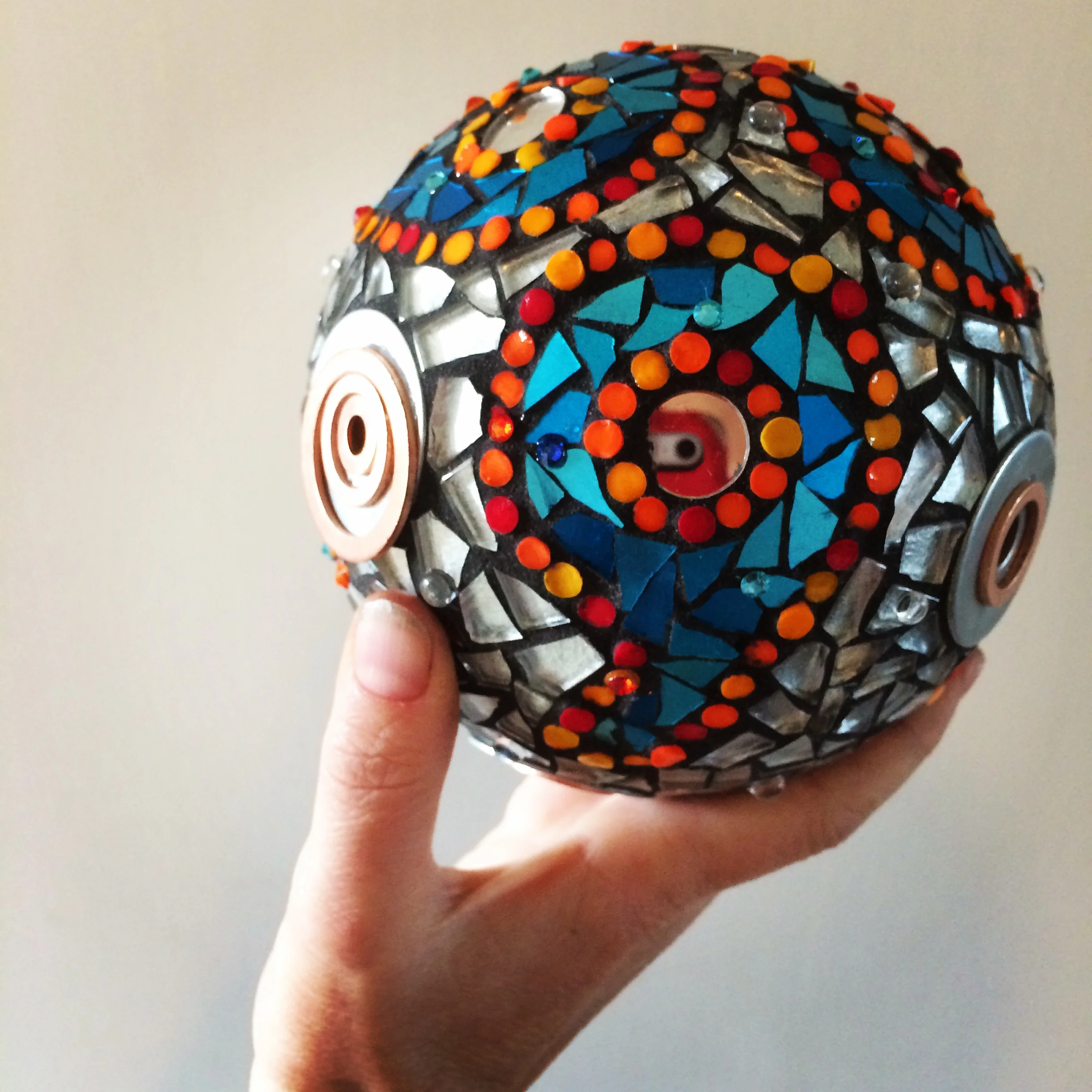  3D sphere, inspired by Andrew Logan's Alternative Miss World.  Smalti, mirror, rods and washers on a polystyrene base.  10cm in diameter. 