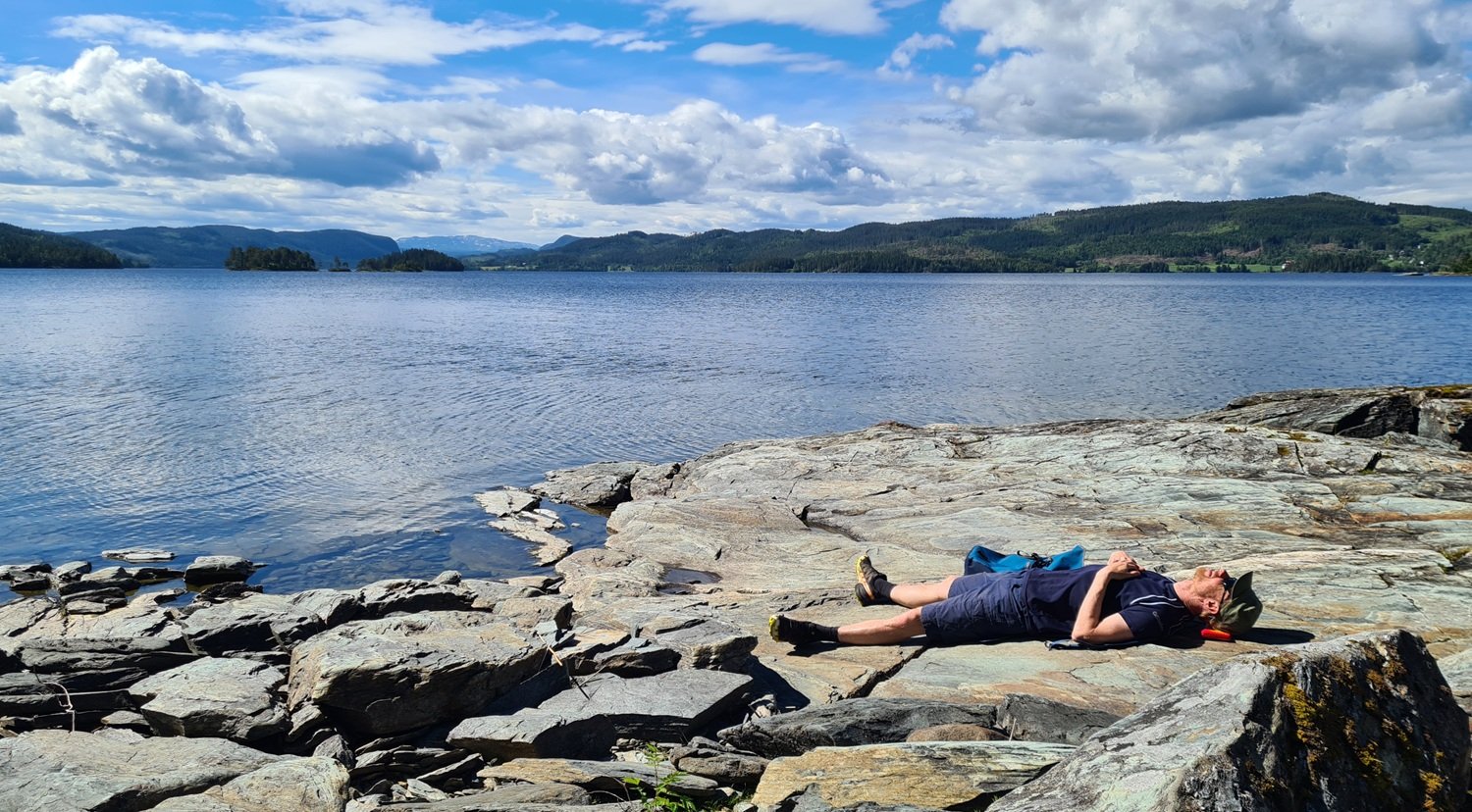Mann slapper av på svaberg.