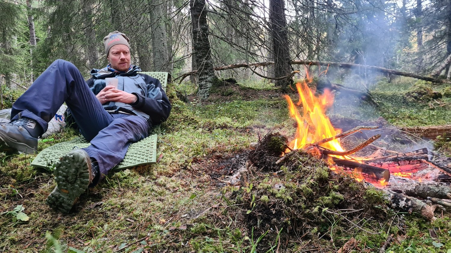 Mann ved bål om morgenen.