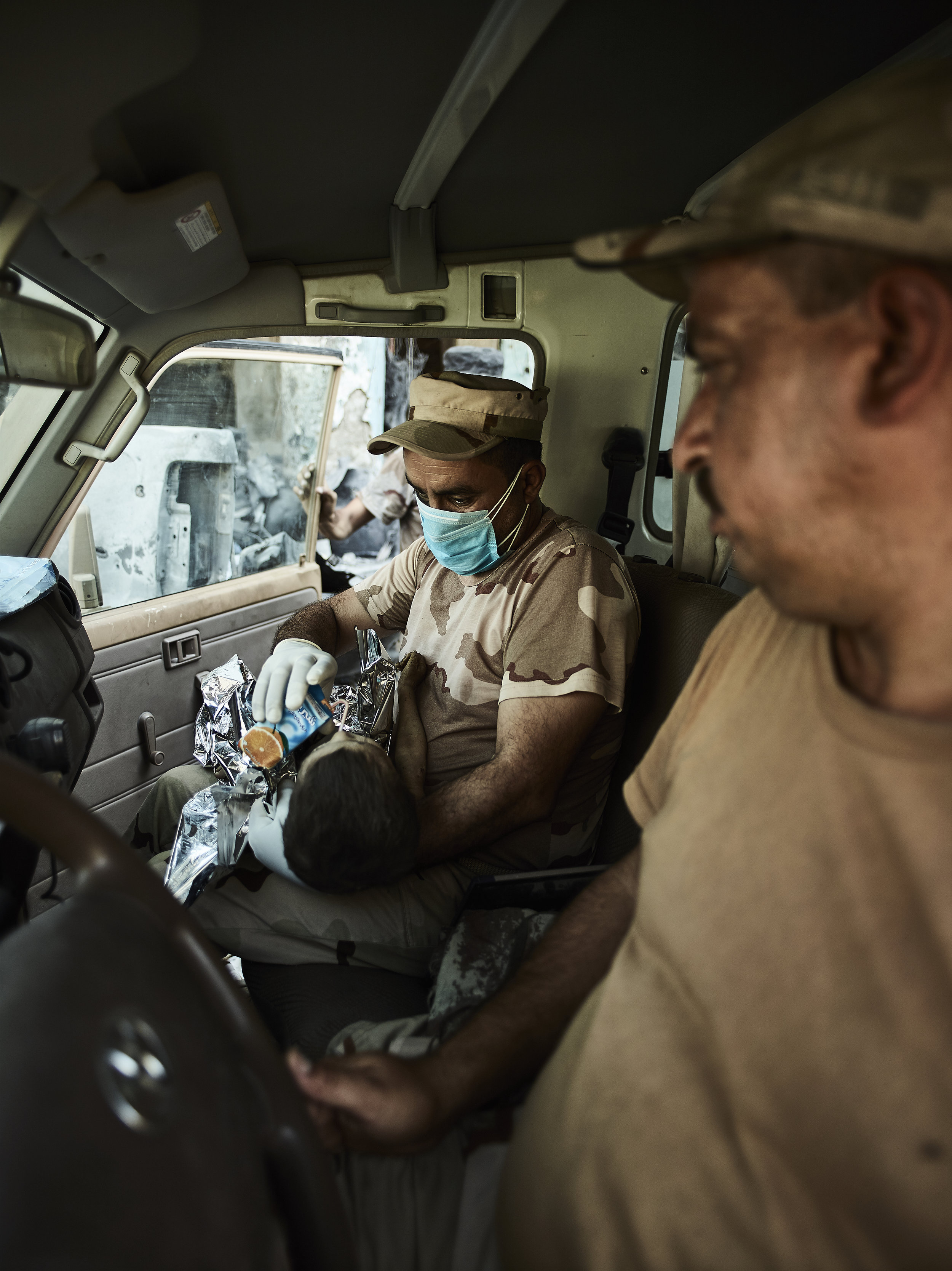 Medics care for a child rescued from the rubble, West Mosul