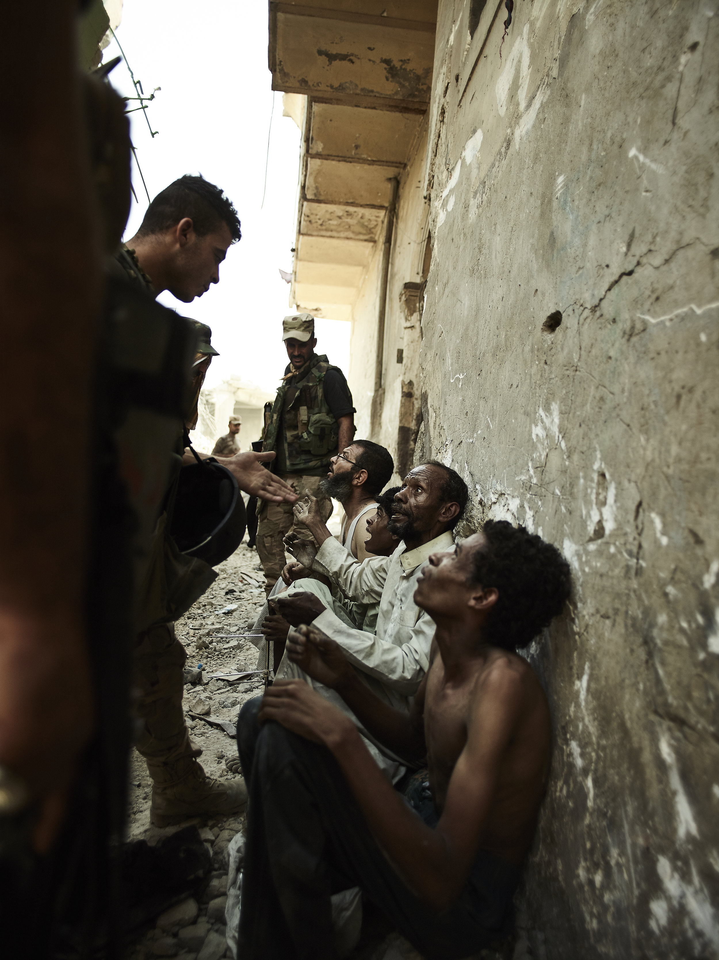 Suspected ISIS militants are interrogated in an alleyway, West Mosul