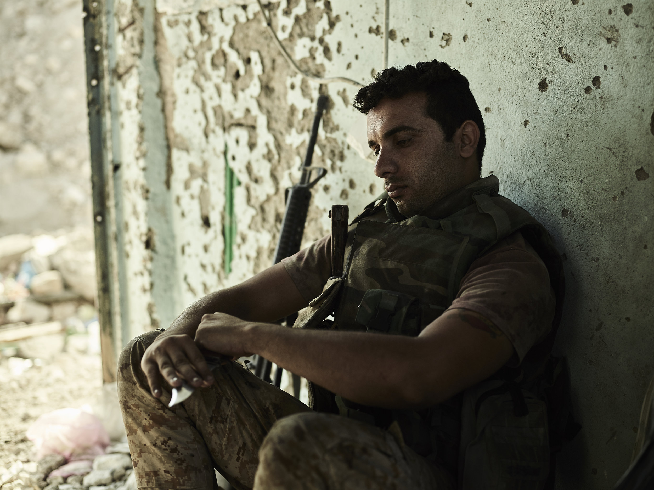 An Iraqi soldier waits at his position on the Tigris River, West Mosul