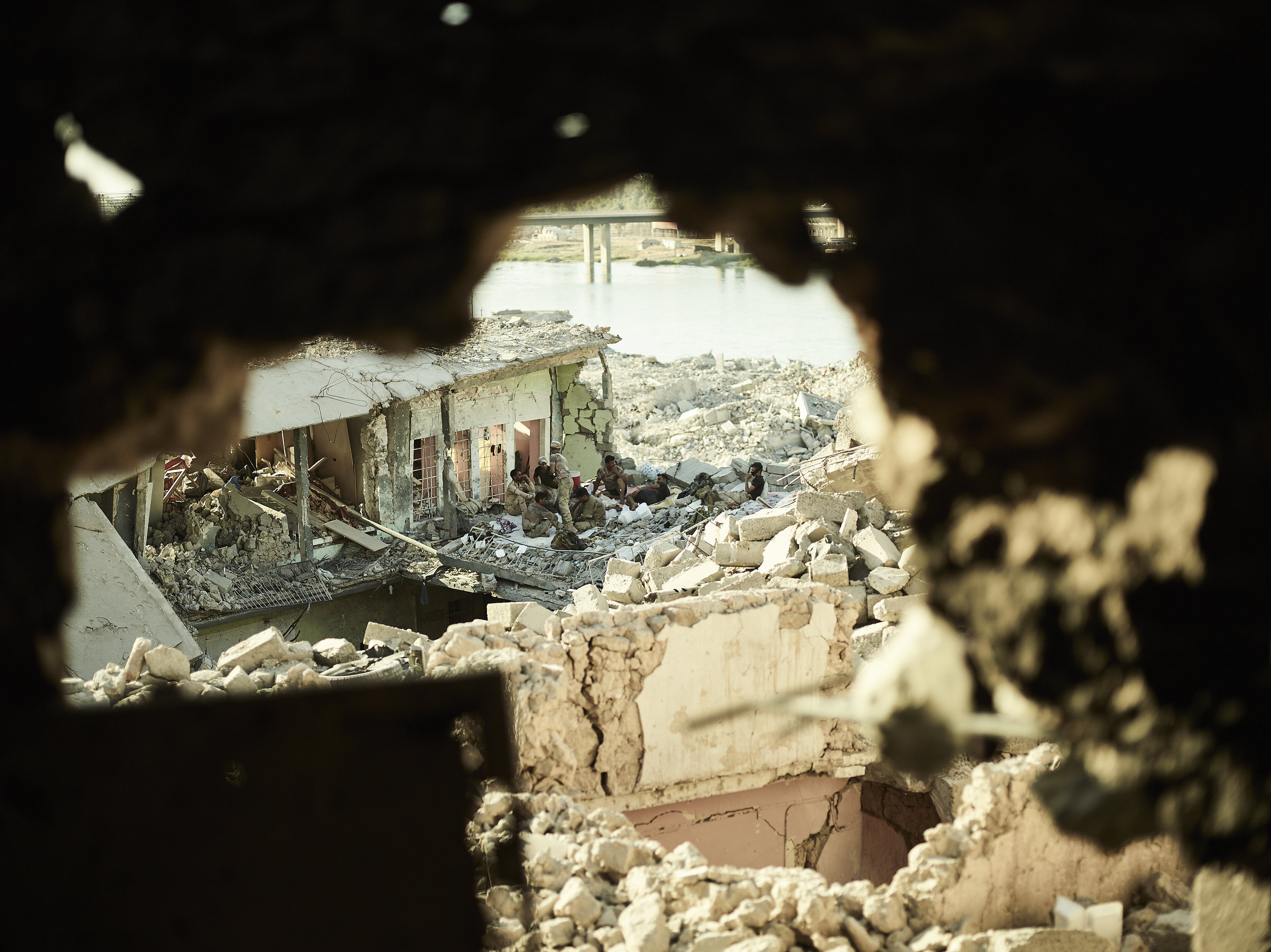 Iraqi soldiers seen through a hole in a building on the Tigris River, West Mosul