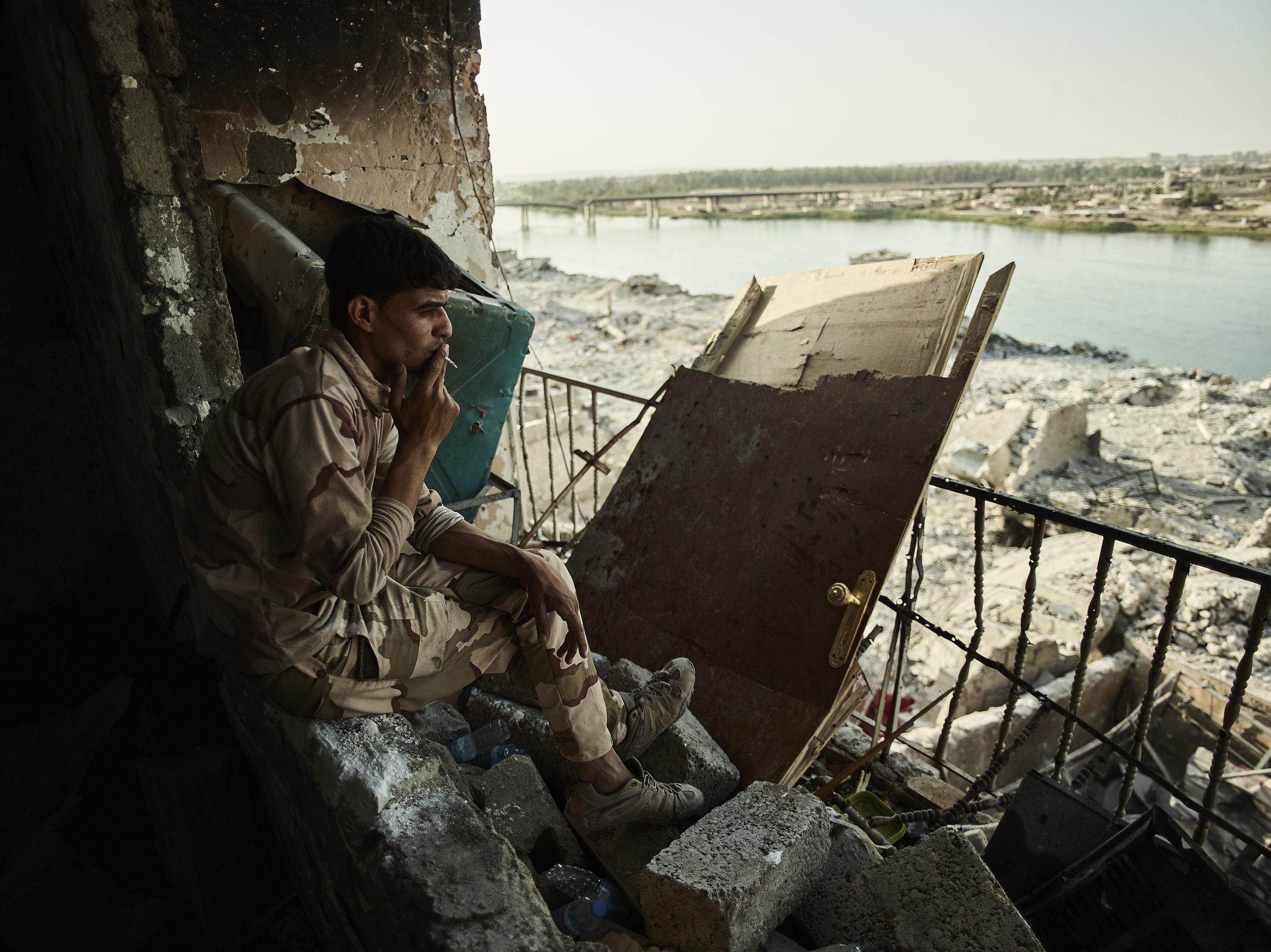A soldier looks out over the last frontline along the Tigris River, West Mosul