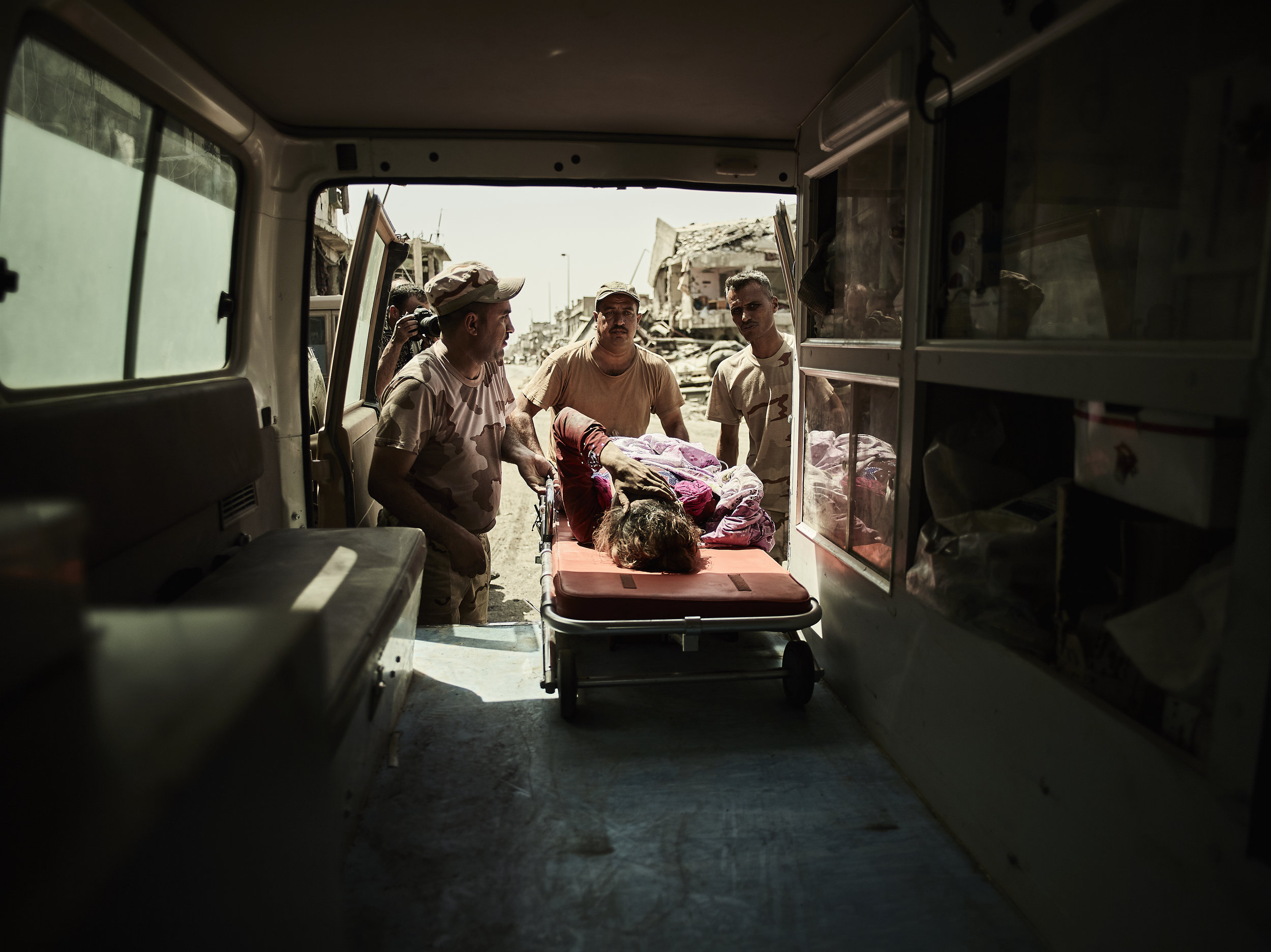 A woman is loaded into an ambulance after being rescued from ISIS, West Mosul