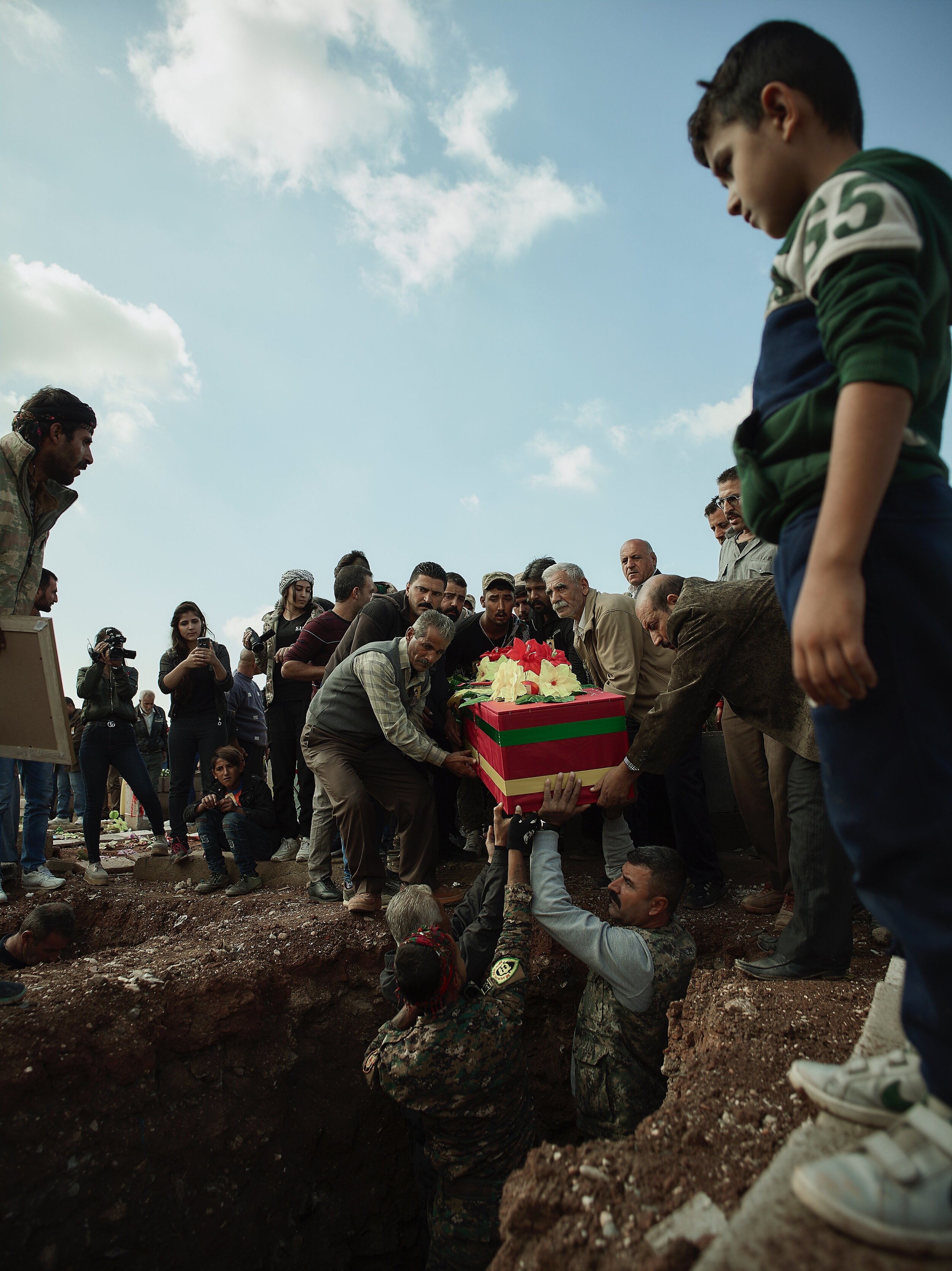 Civilians in Qamishlo bury the body of a soldier killed by Turkish Forces