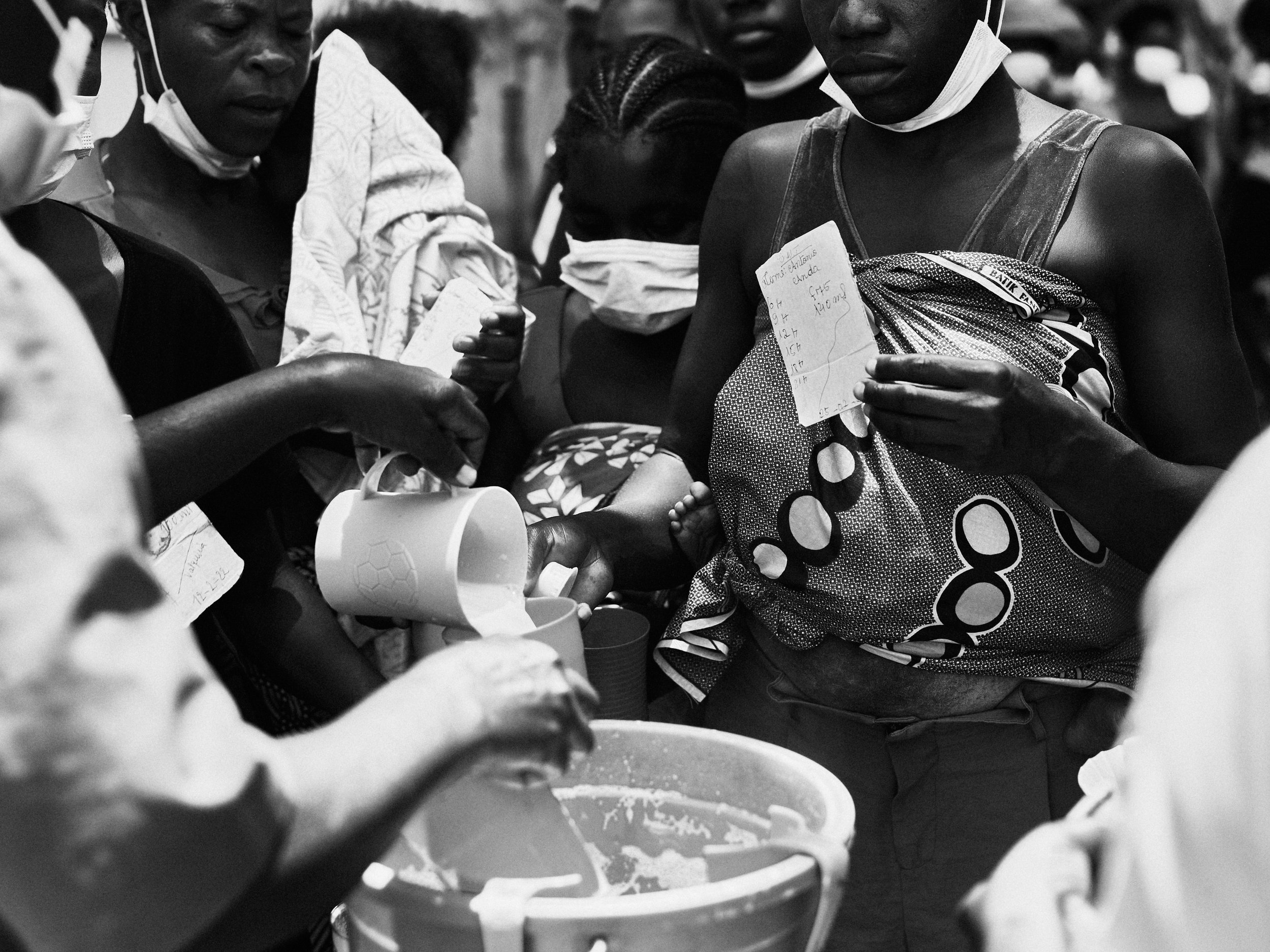 Mothers receiving milk rations at a malnutrition clinic, Luanda, Angola