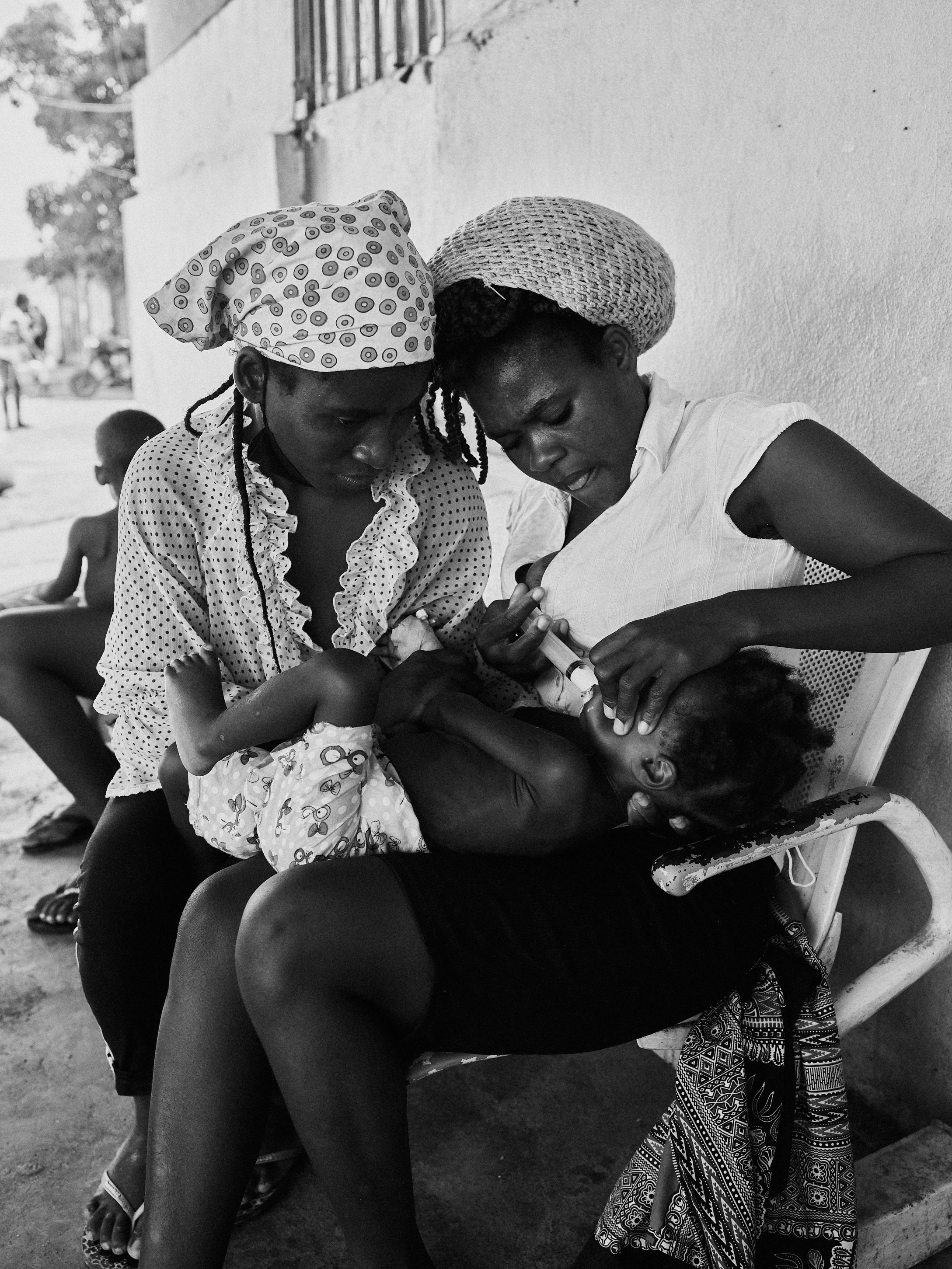 A mother force-feeds her child, Luanda, Angola