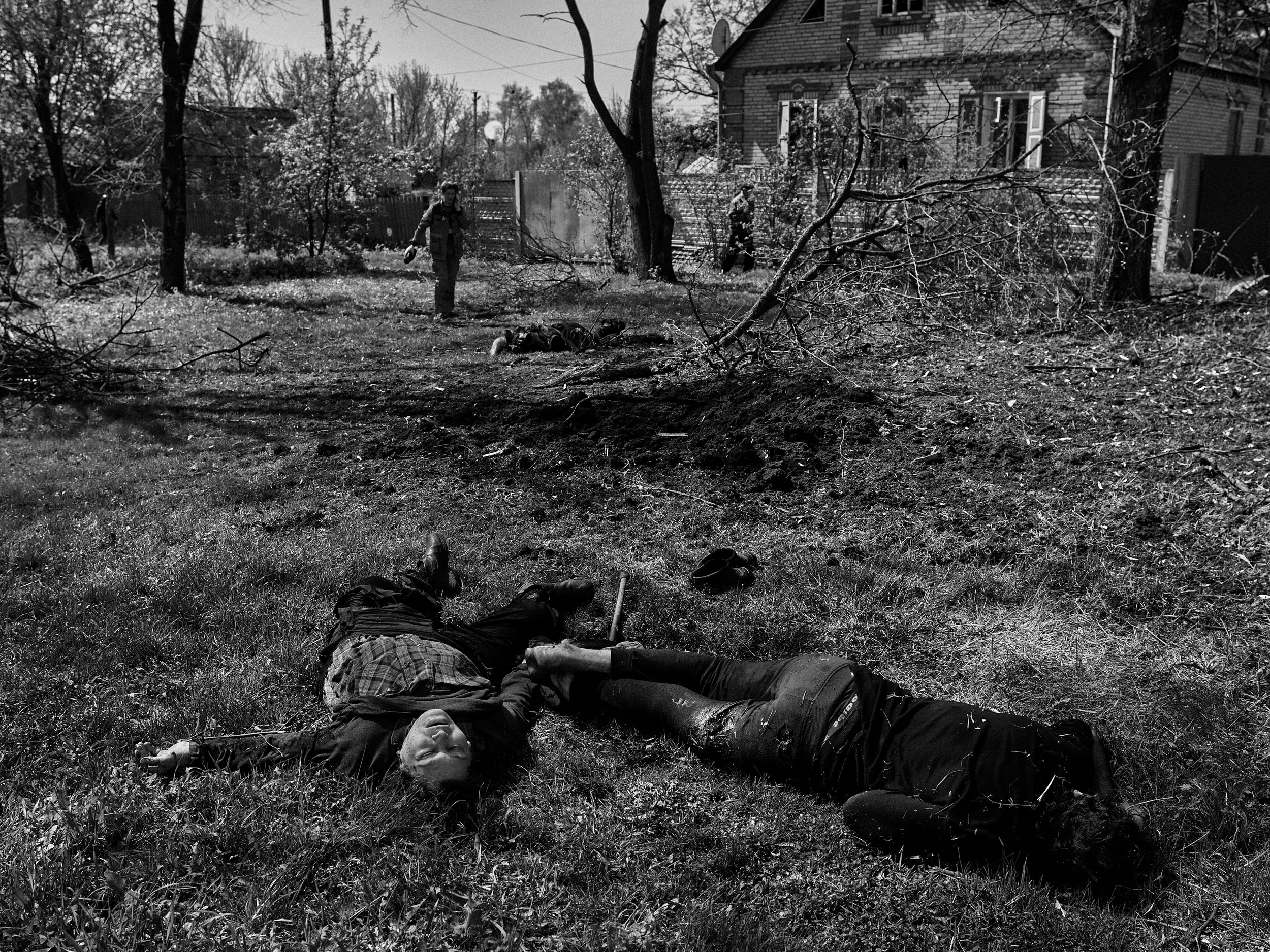 A family killed by mortars lie dead in their front yard. Bezruky Village, Kharkiv Oblast