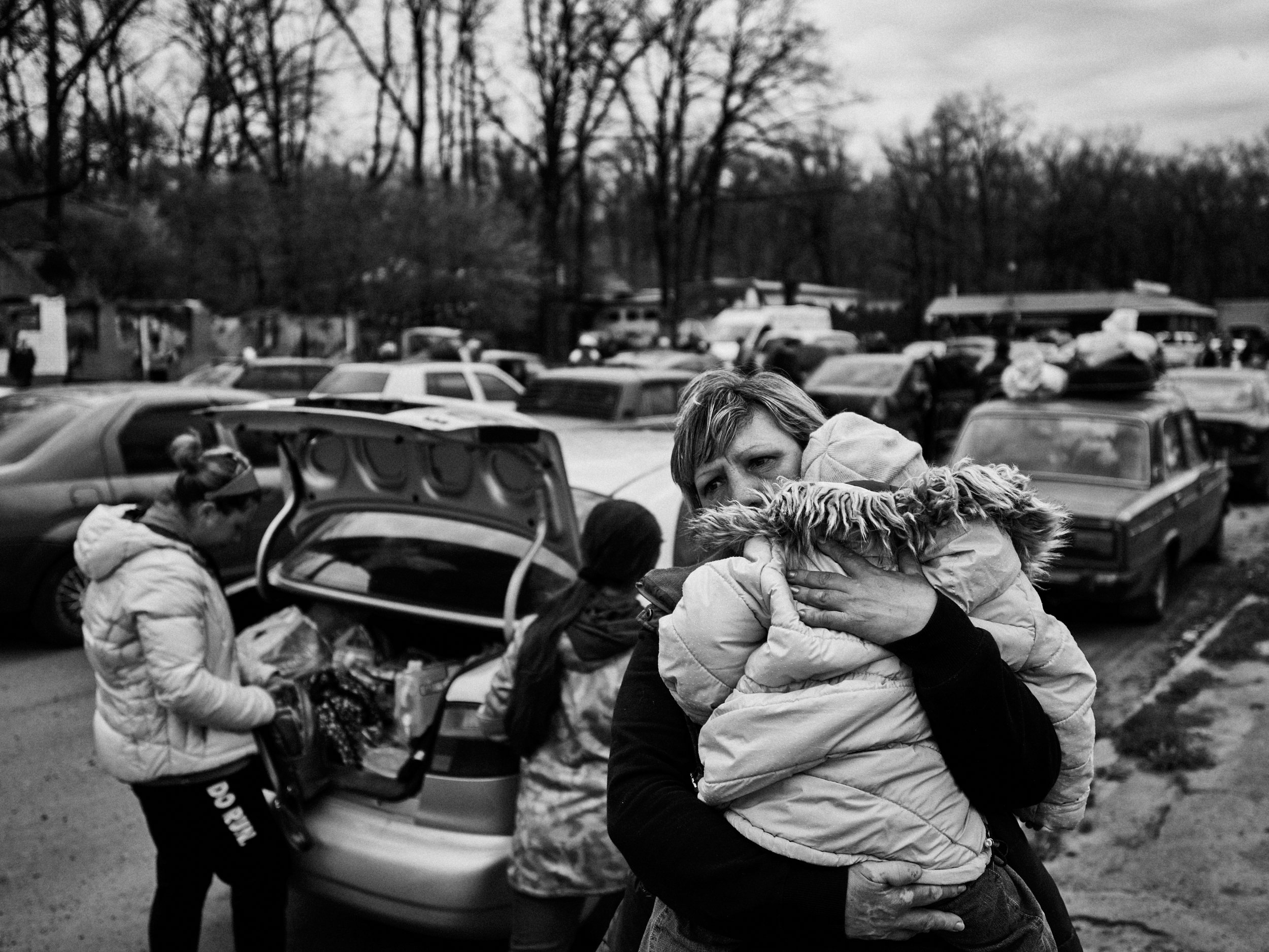 Civilians wait at an evacuation point after fleeing Russian-occupied Ruska Lozova, Kharkiv Oblast