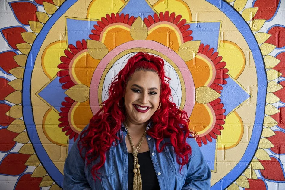 Host Claudia Sandoval in front of wall art.jpg