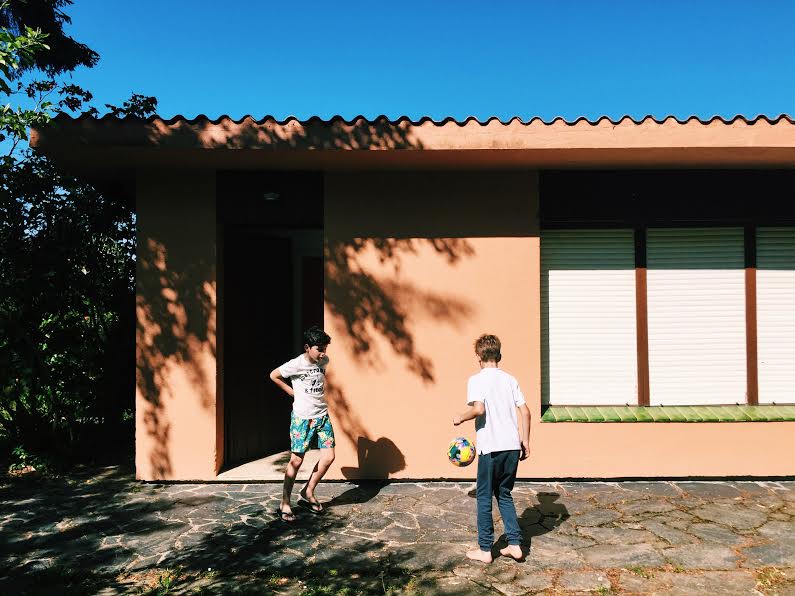 Alvaro and his cousin kicking the soccer ball against the beach house 