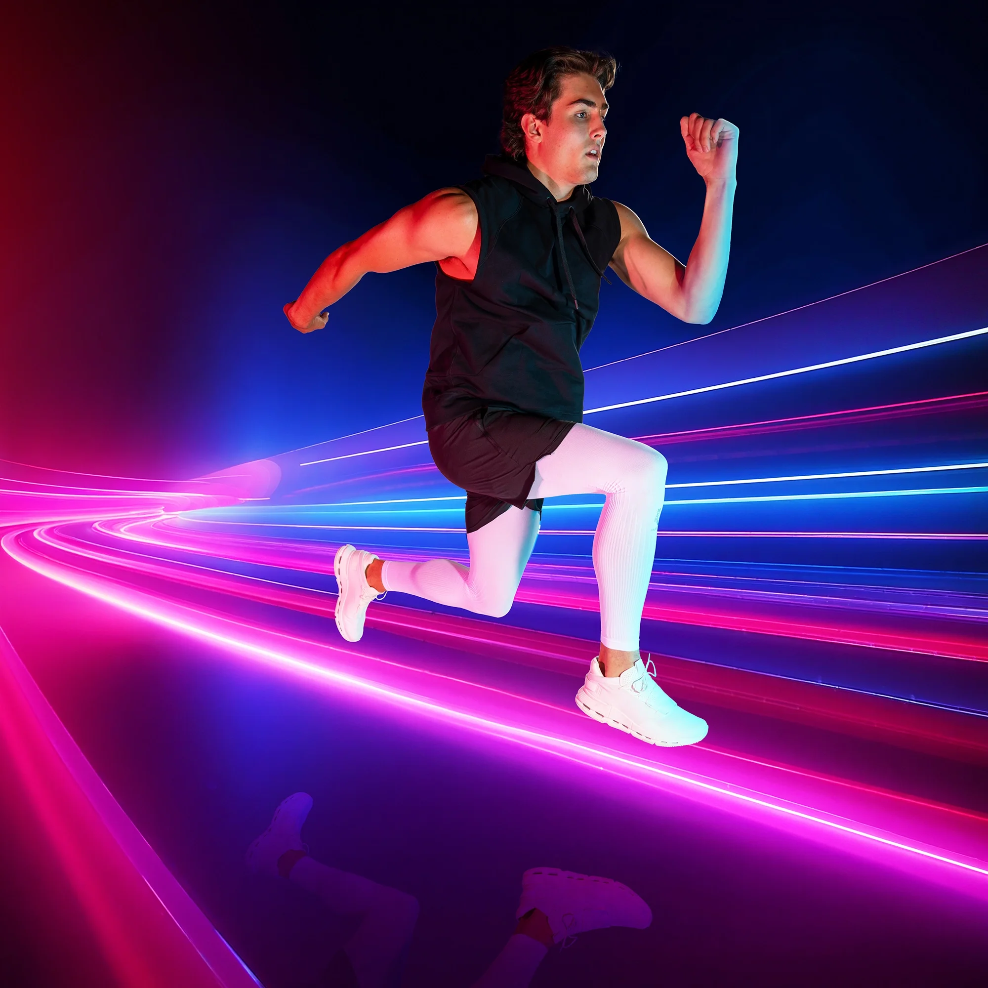 Young man in athletic clothing running through a tunnel with neon lights creating a colorful glowing effect.